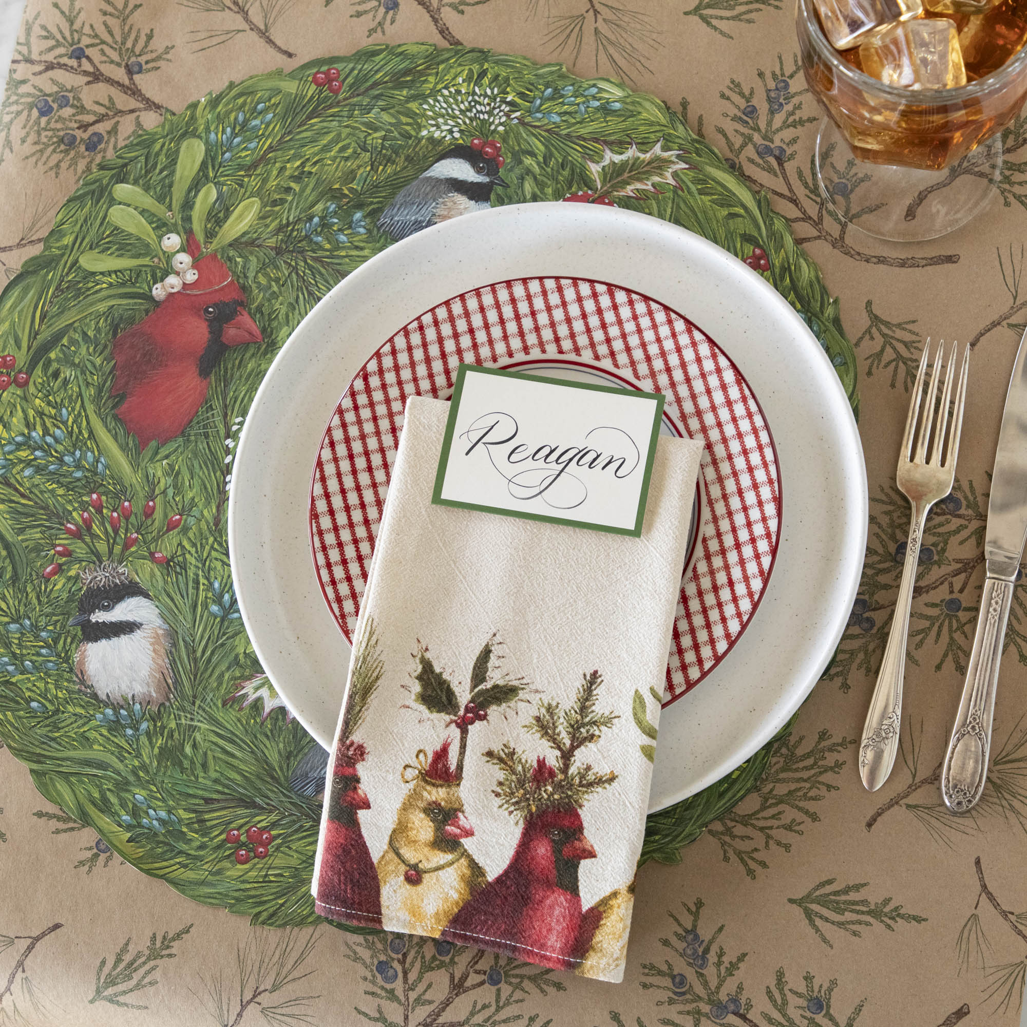 A nature themed table setting featuring the Holiday Party Cardinal Napkin resting on dinner plates.