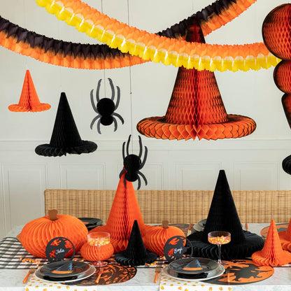 A Halloween themed table setting with Halloween Honeycomb Garland strung over above the table.