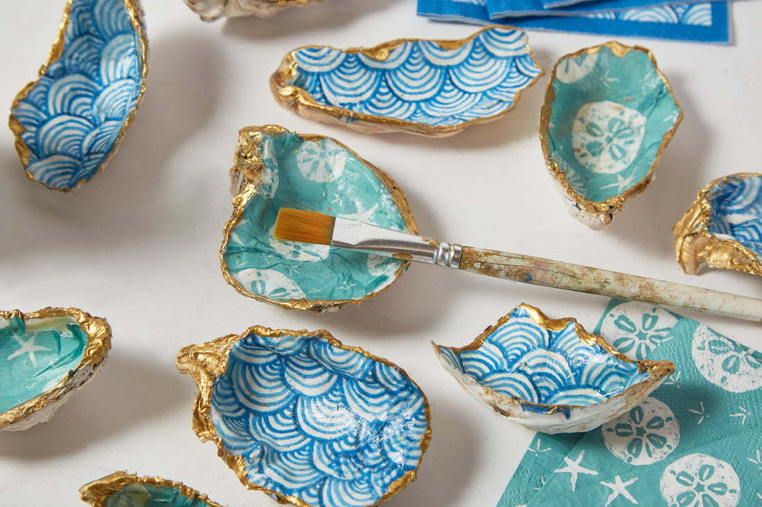 Decorative oyster shells with blue and white patterns on a white surface.