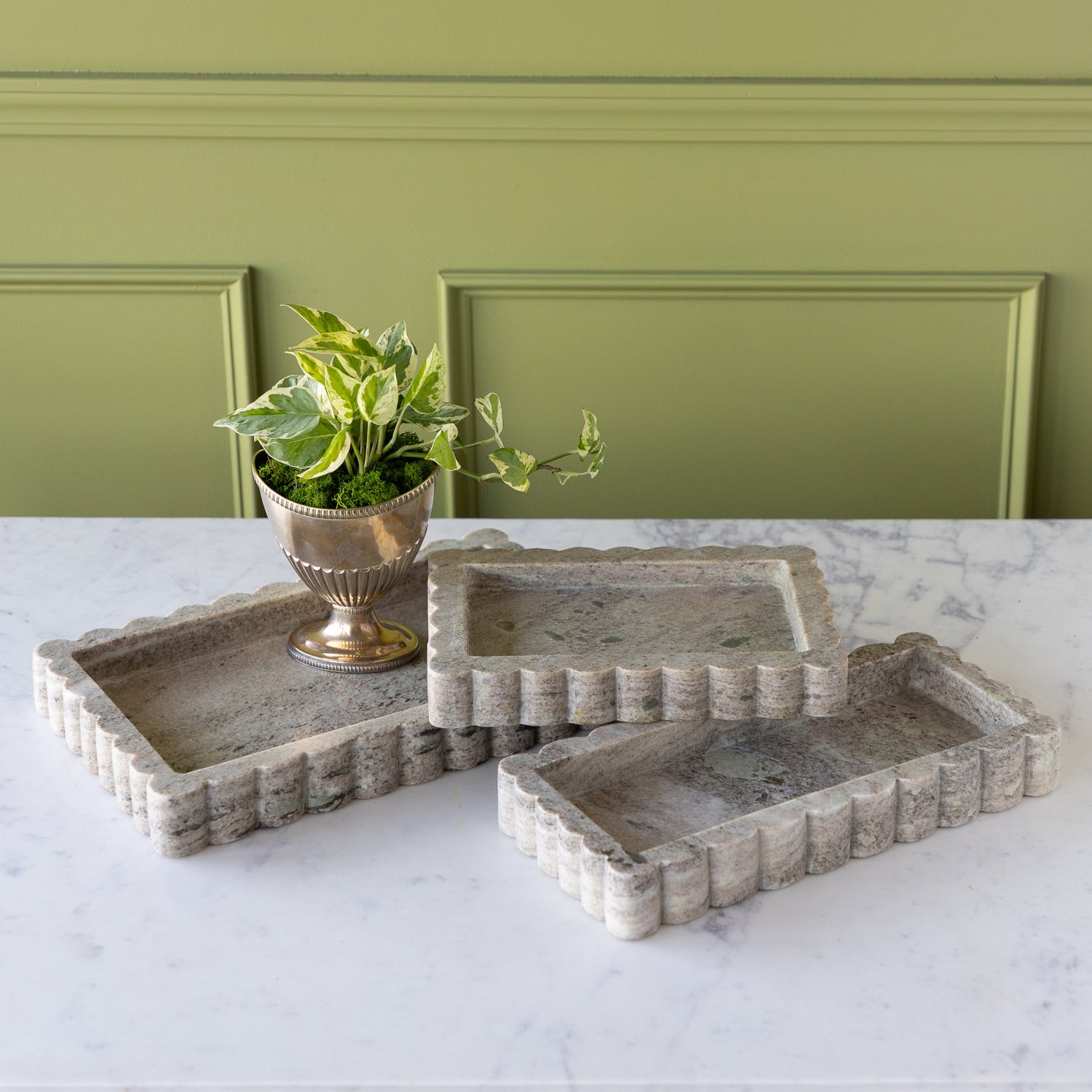 Intricate Scallop Marble Trays in 3 sizes with a potted plant in one.