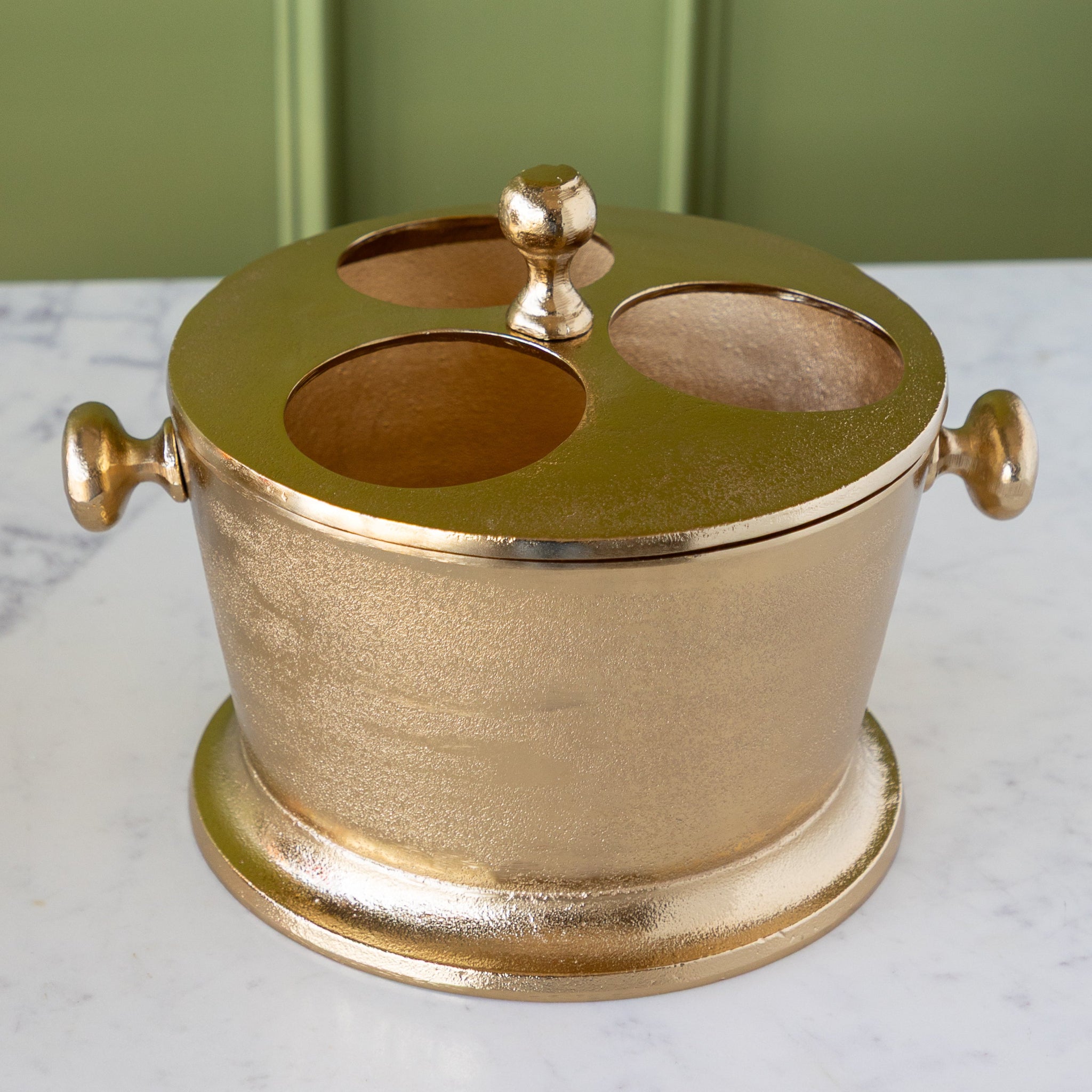 Gold Raw Aluminum Bottle Holder with 3 circular holes for wine bottles, a knob in the center and on both sides of the bucket.