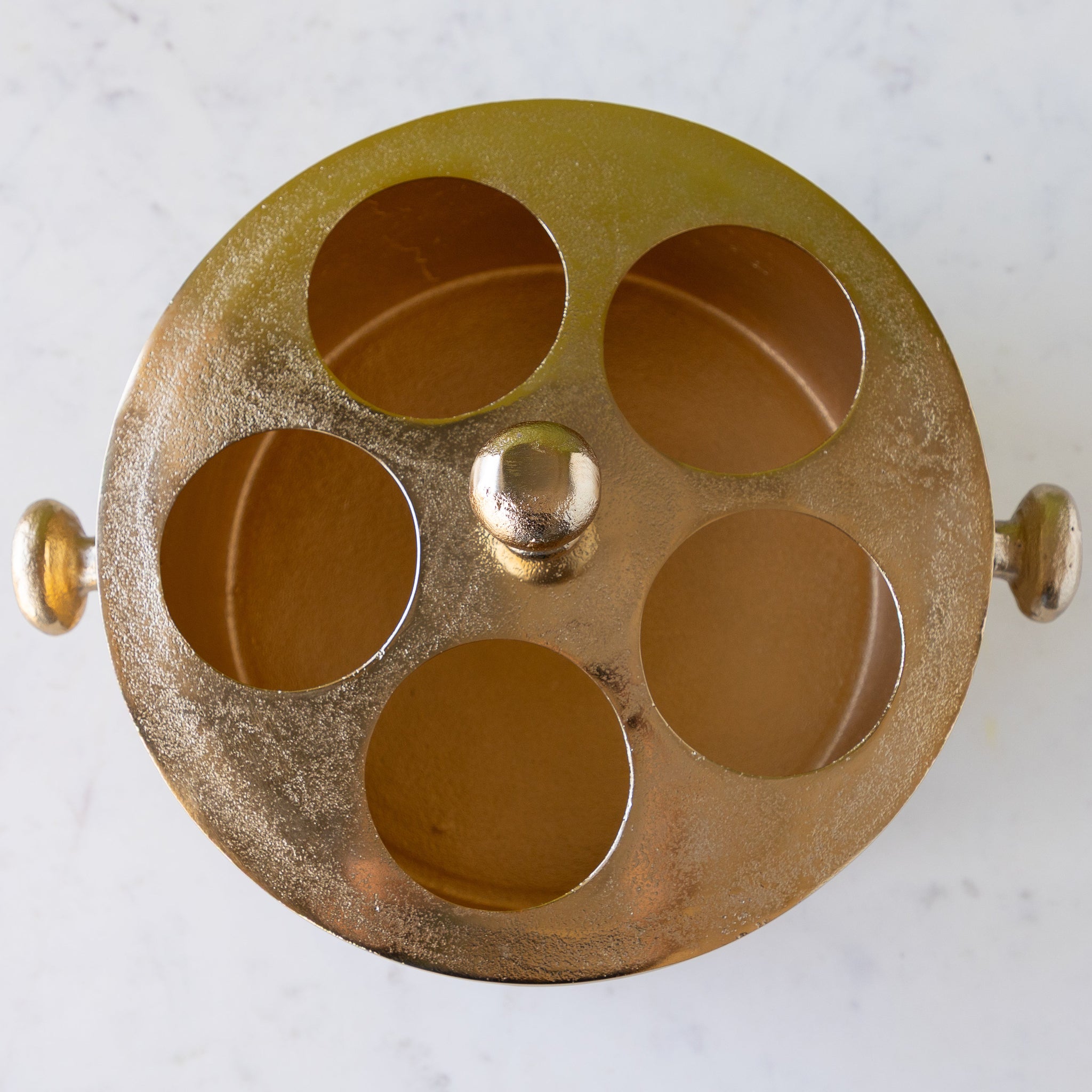 Gold Raw Aluminum Bottle Holder with 5 circular holes for wine bottles, a knob in the center and on both sides of the bucket.
