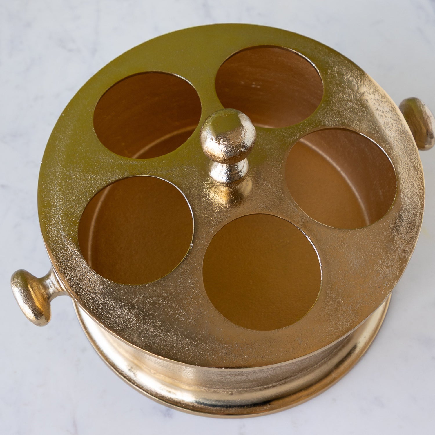 Gold Raw Aluminum Bottle Holder with 5 circular holes, a knob in the center and on both sides of the bucket.