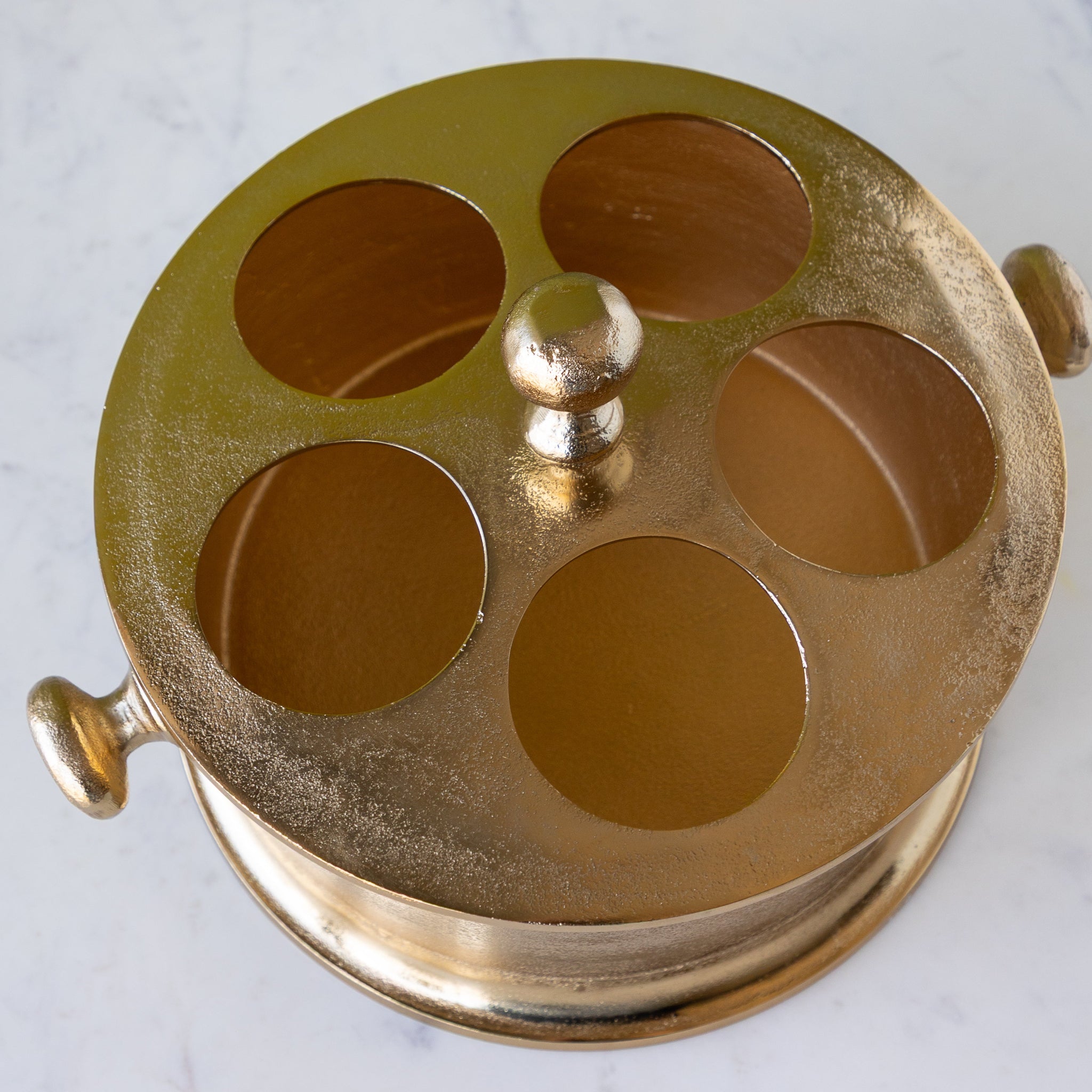 Gold Raw Aluminum Bottle Holder with 5 circular holes, a knob in the center and on both sides of the bucket.