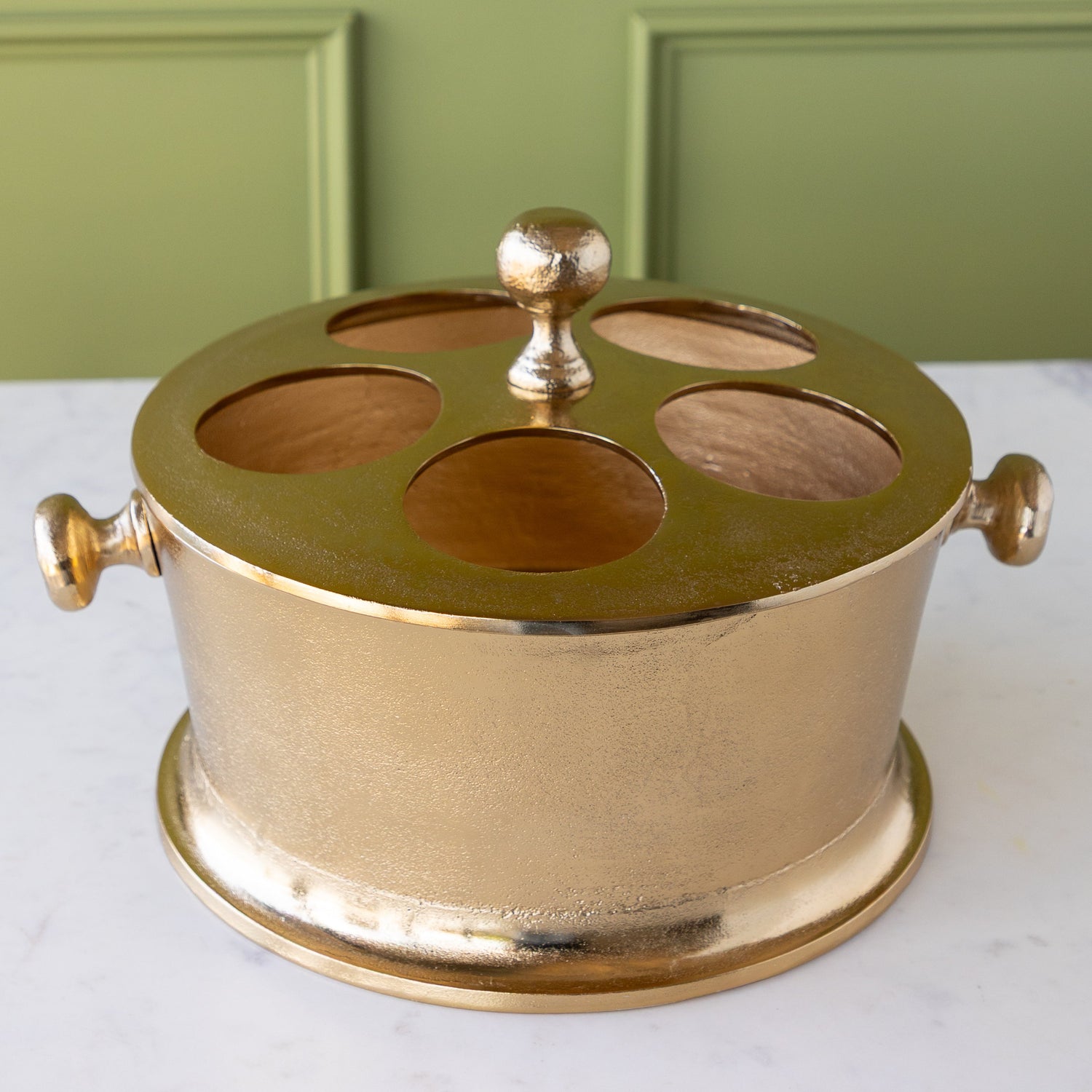 Gold Raw Aluminum Bottle Holder with a knob in the center and on both sides of the bucket.