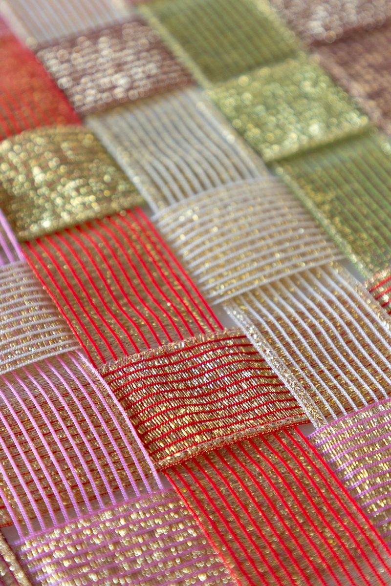 A surface woven with sparkle ribbon in five different colors.
