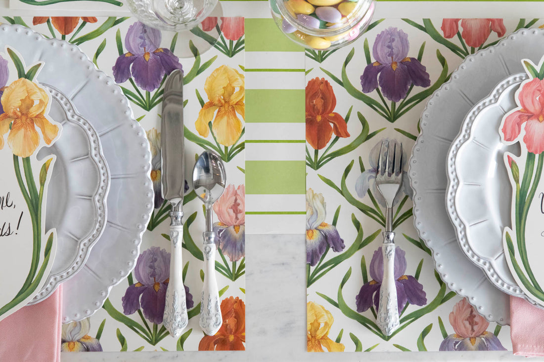 Close-up of the Field of Irises Placemat under two elegant spring-themed place settings, from above.