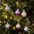 Decorative cupcake ornaments on a Christmas tree with lights.