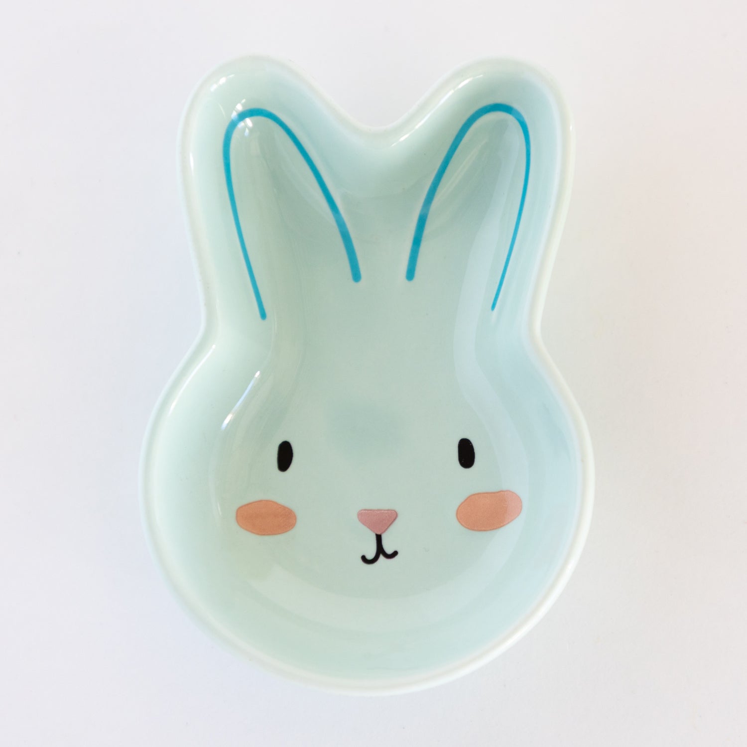 Teal, ceramic rabbit-shaped bowl on a marble table.