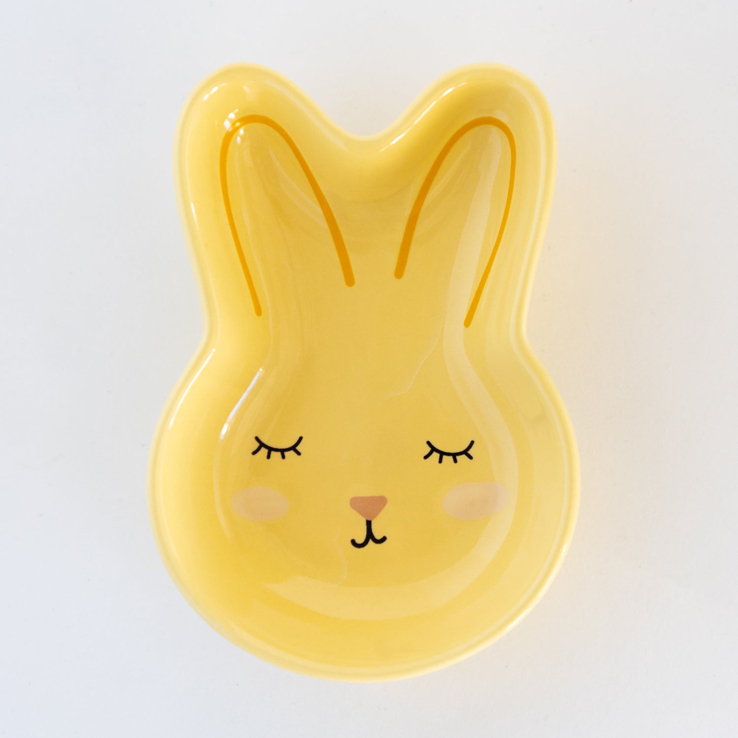 Yellow rabbit-shaped dish with a cute face on a white background.