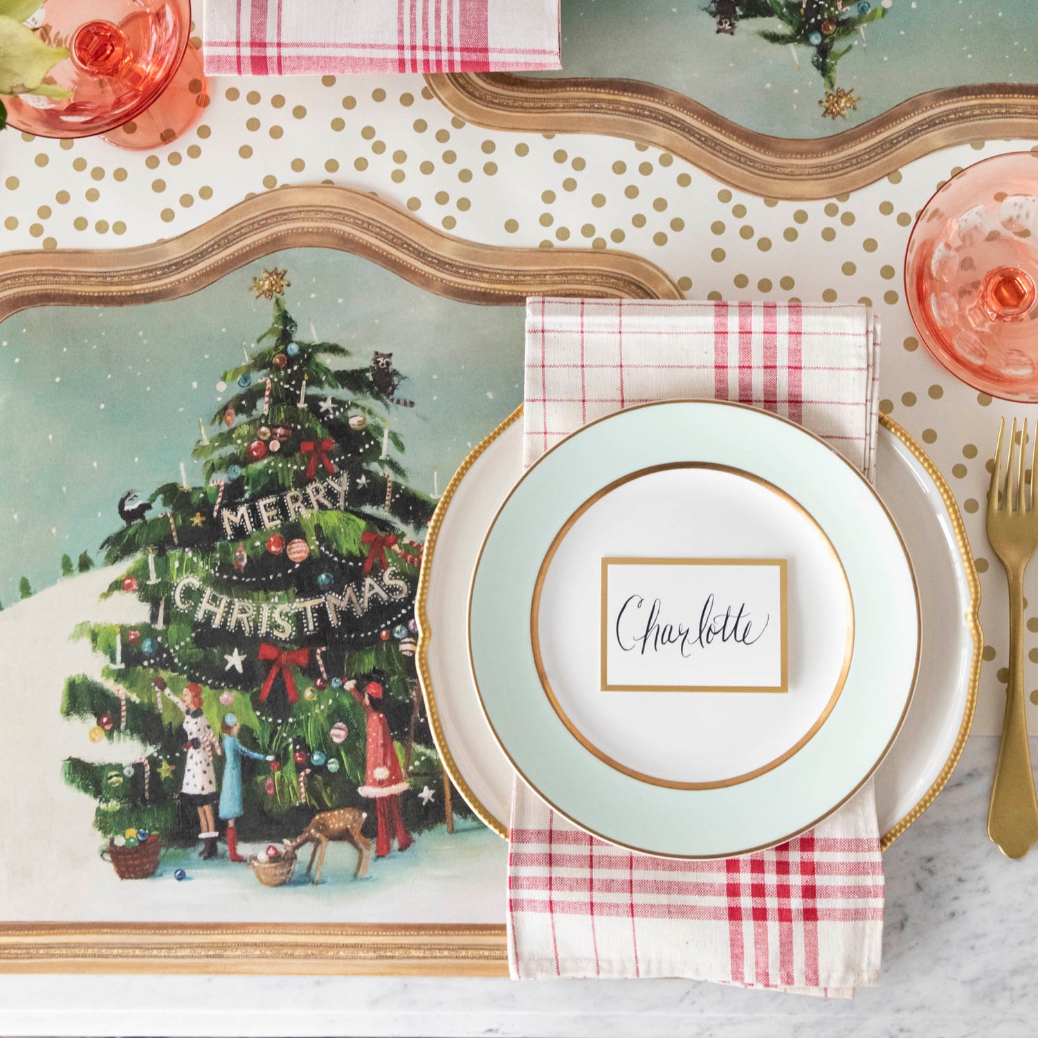 The Die-cut Trim the Tree Placemat under an elegant Christmas-themed table setting, from above.