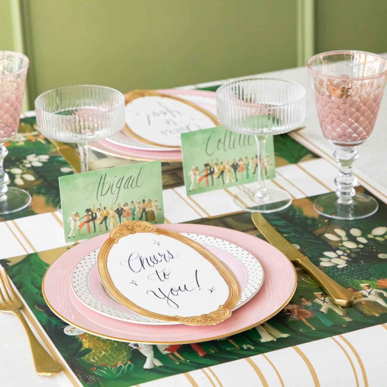 The Antique Gold Frame Table Card with &quot;Cheers to you!&quot; written on it, resting on a dinner plate on an elegant table setting.