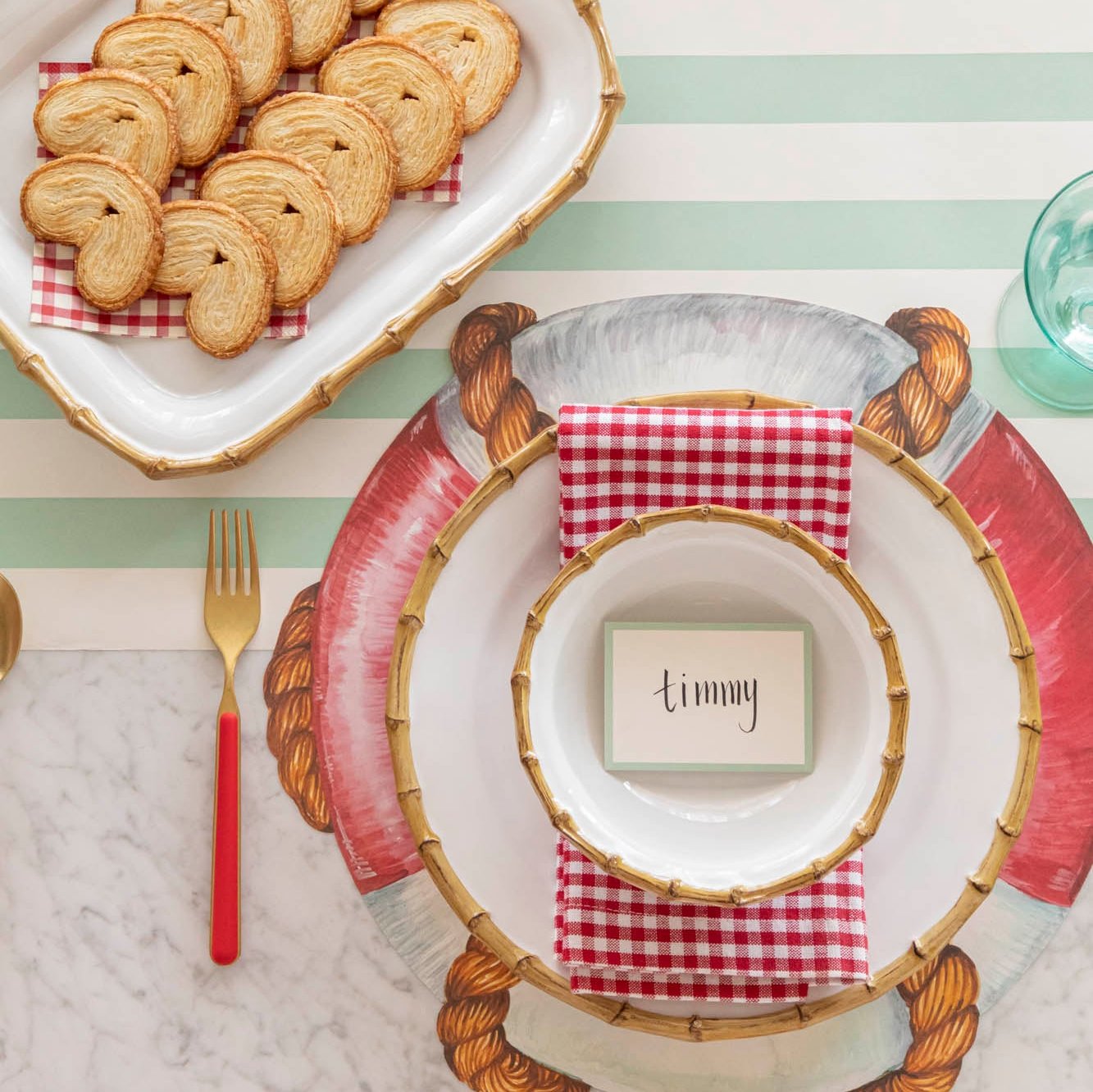 The Die-cut Life Preserver Placemat under an elegant nautical-themed place setting, featuring Juliska Bamboo Dinnerware.