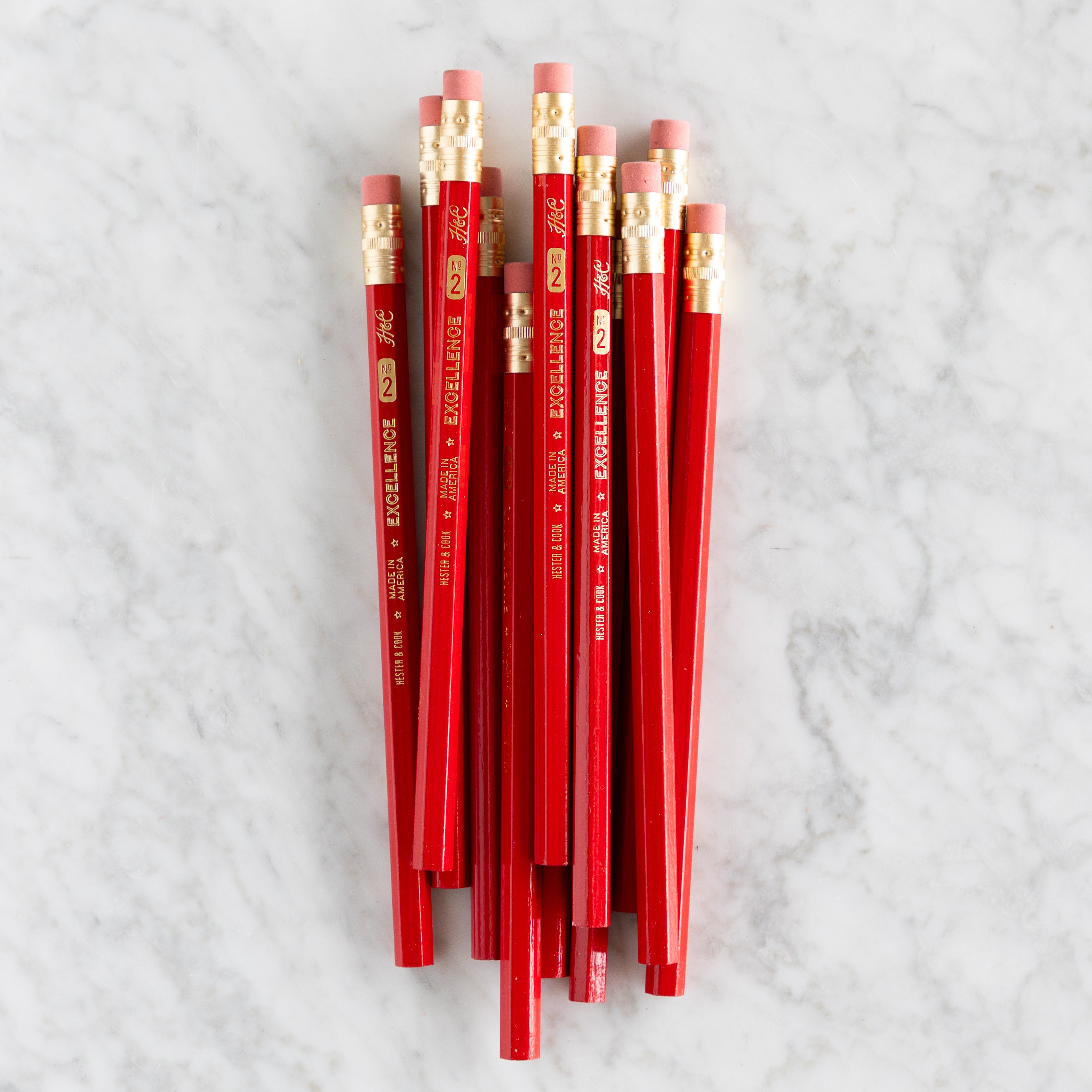 Jumbo Hex Red Pencils grouped together on a marble background. 