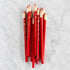Jumbo Hex Red Pencils grouped together on a marble background. 