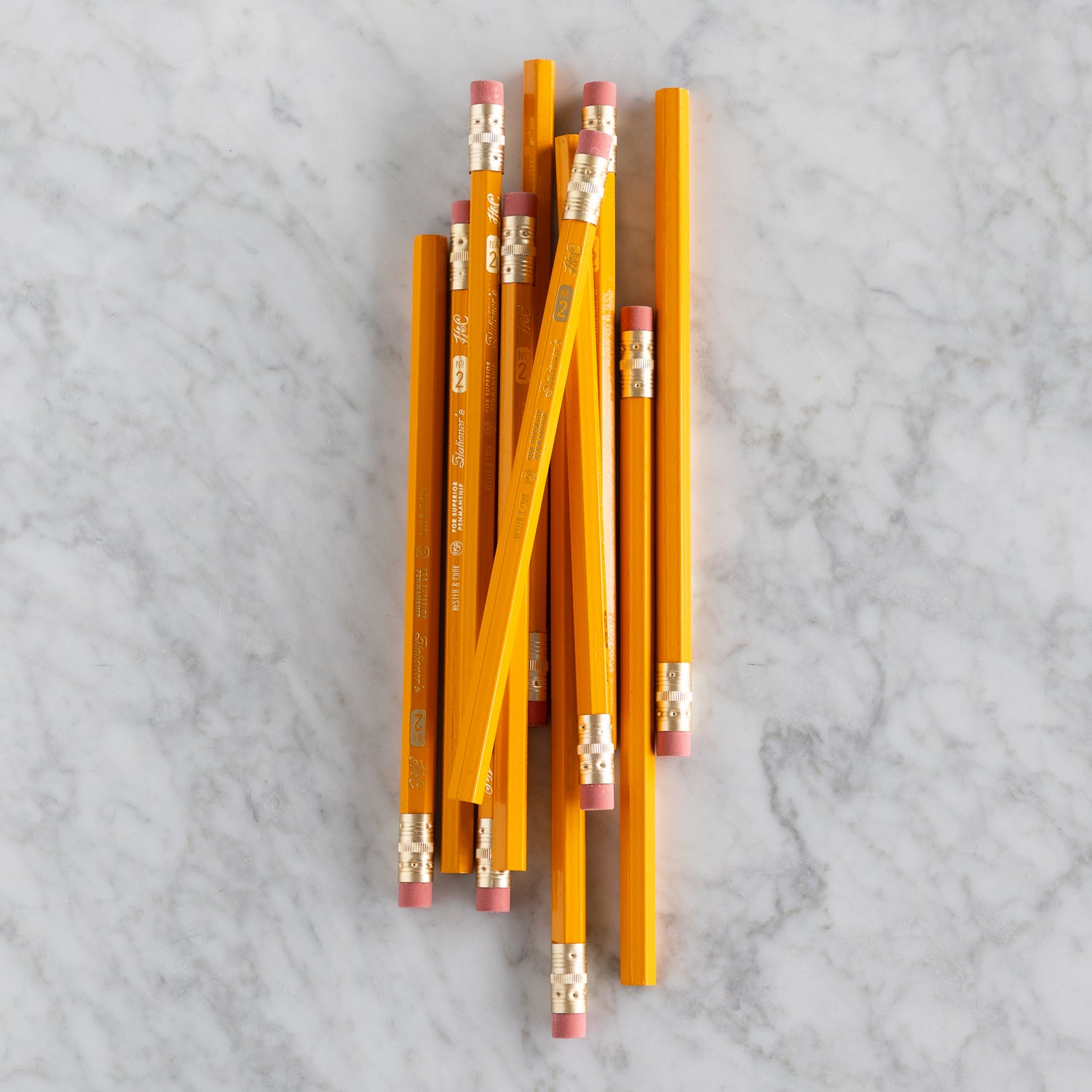 Yellow Jumbo Hex Pencils grouped together on a marble surface. 