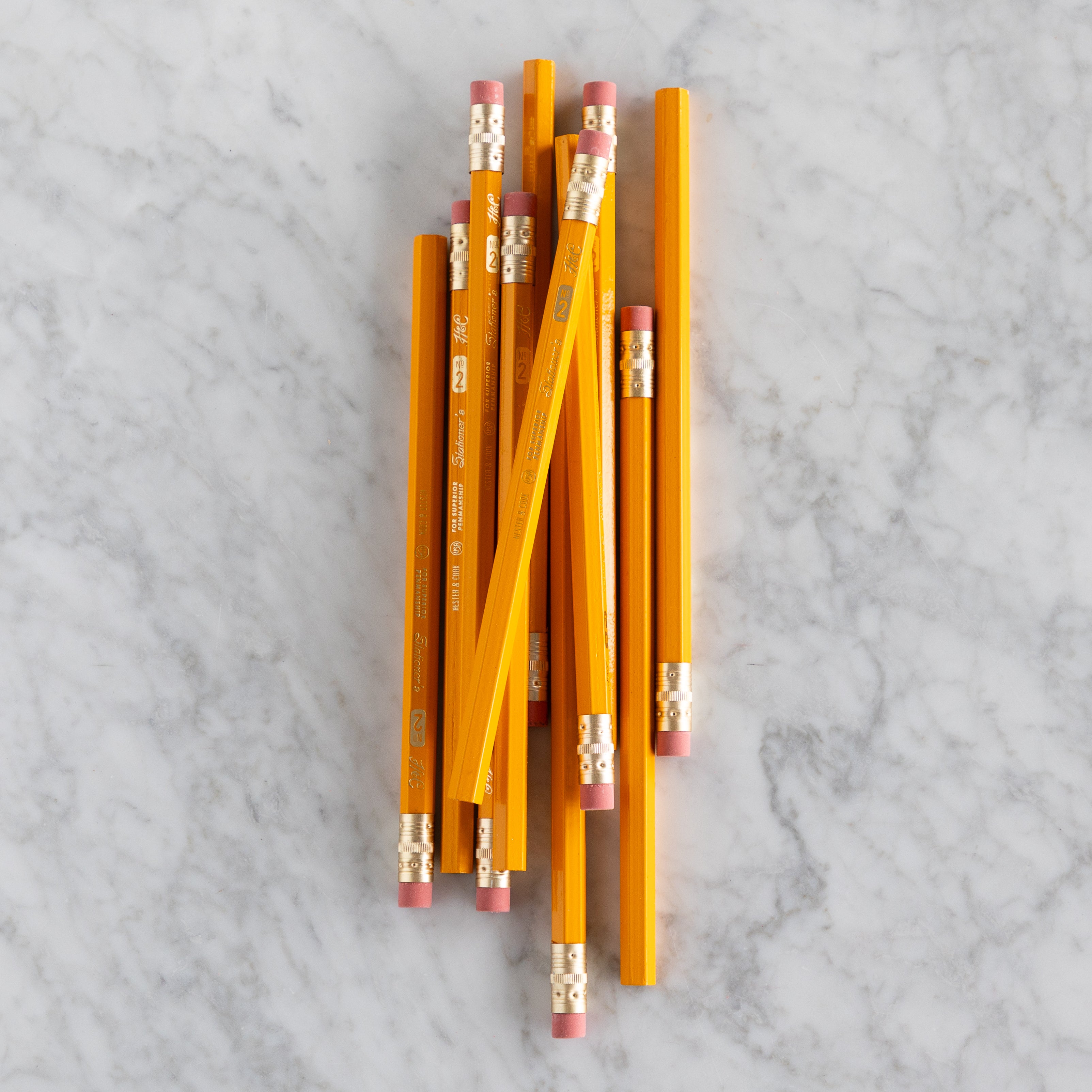 Yellow Jumbo Hex Pencils grouped together on a marble surface. 