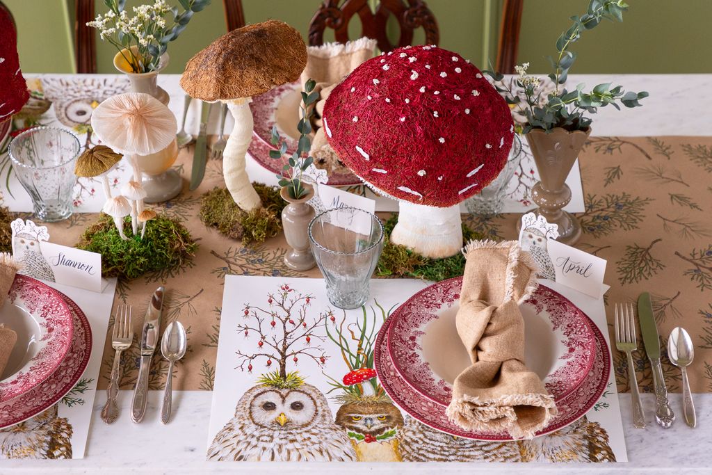Decorative table setting with mushroom-themed centerpieces and patterned tablecloth.