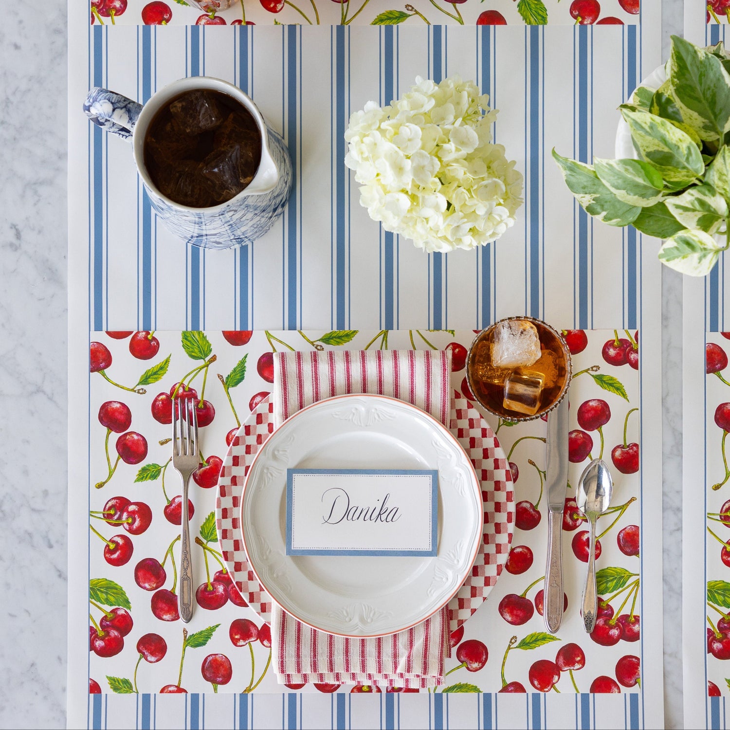 Table setting with the Cherries Placemat, Cornflower Blue Place Card, vintage dinnerware, and floral decorations on the Cornflower Blue Linen Stripe Runner.