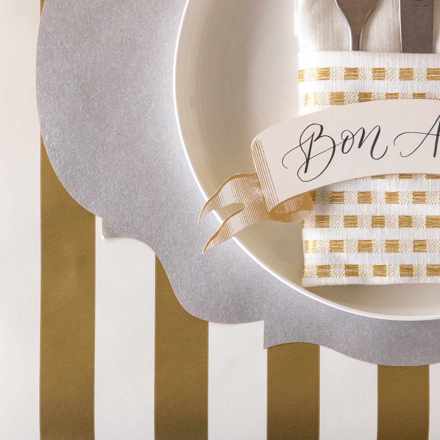 A place setting with the Die-cut Silver French Frame Placemat on the Gold Classic Stripe Runner.
