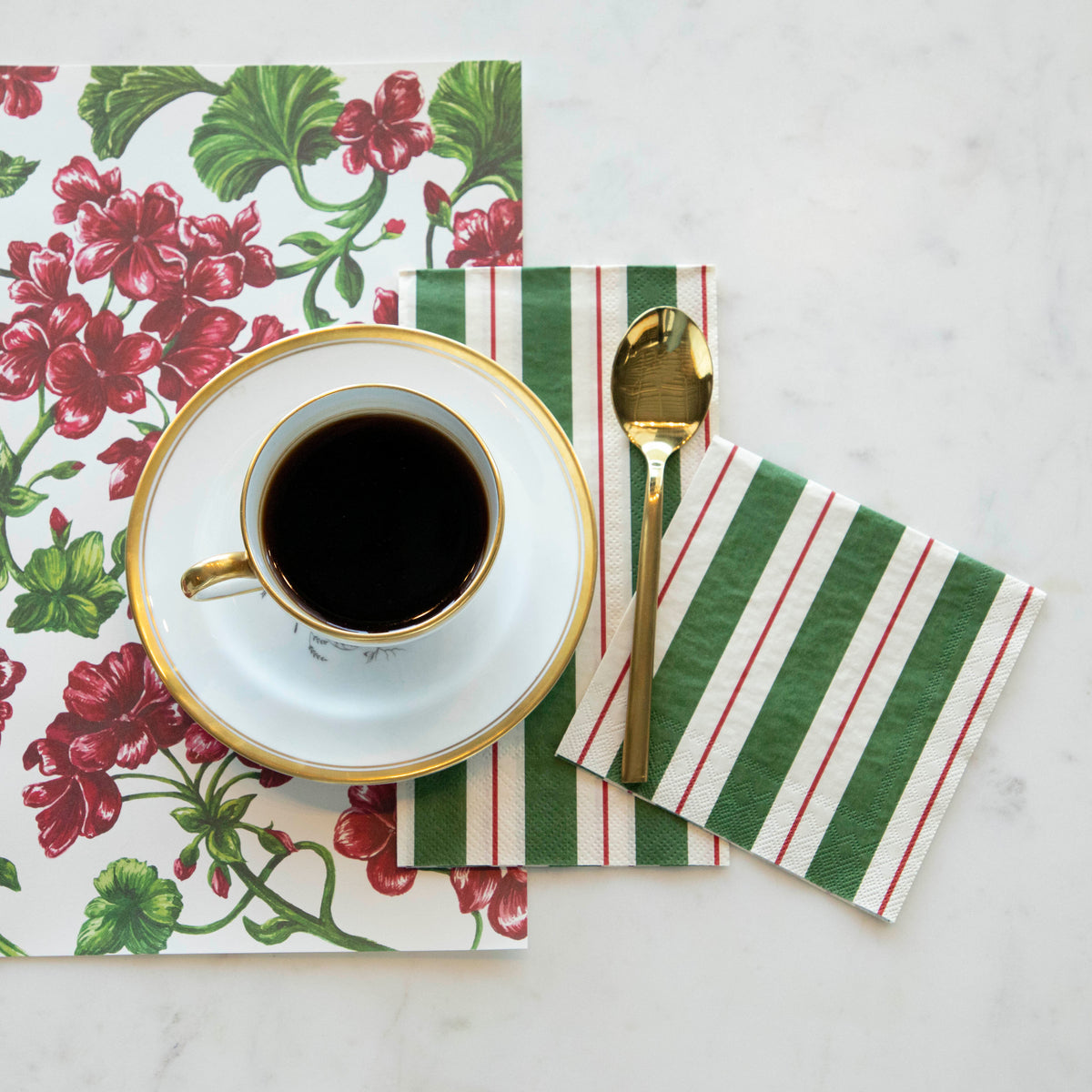 A cup of coffee sits on a Green &amp; Red Awning Stripe napkin, elegantly placed in a table setting by Hester &amp; Cook.