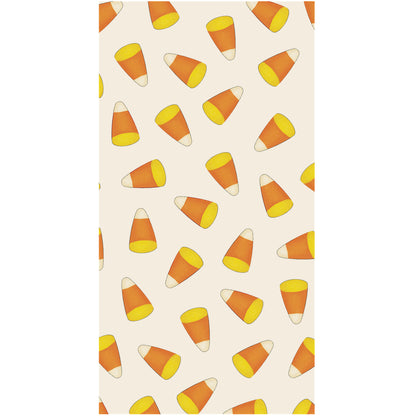A rectangle, cream guest napkin scattered with yellow, orange and white candy corn.