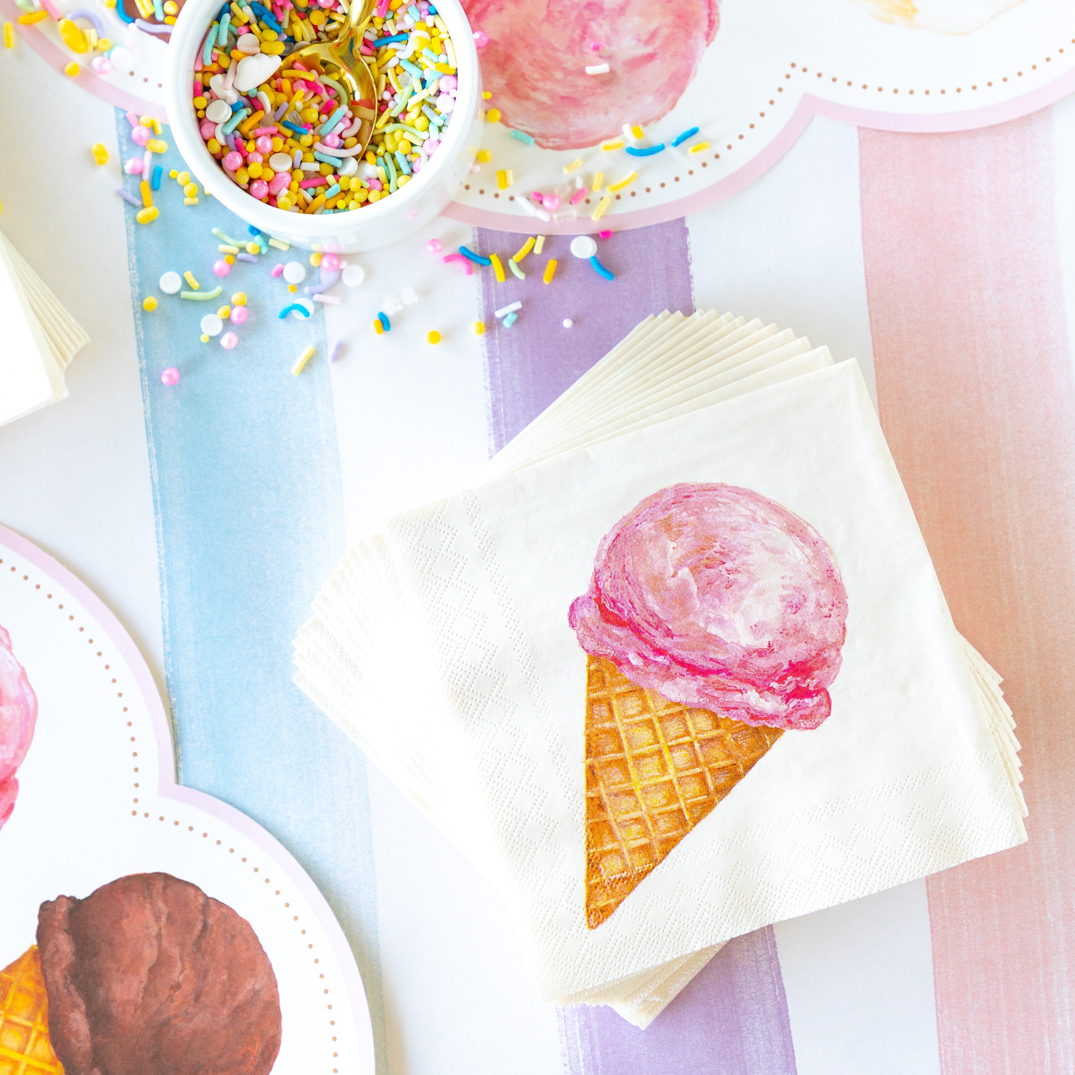 Stack of Ice Cream Cocktail Napkins and a cup of sprinkles on the Sorbet Painted Stripe Runner.