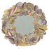 The Die-cut Shell Wreath Placemat featuring swirling nautilus and scalloped clam shells with a blue center.