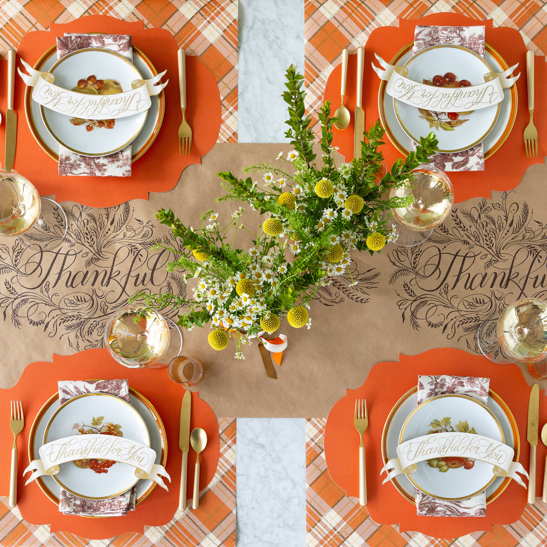 The Thankful Runner under a fall table setting with the Die-cut Orange French Frame Placemats, vintage dinnerware, floral napkins, gold and peach flatware, and Thankful For You Banner Table Accent.