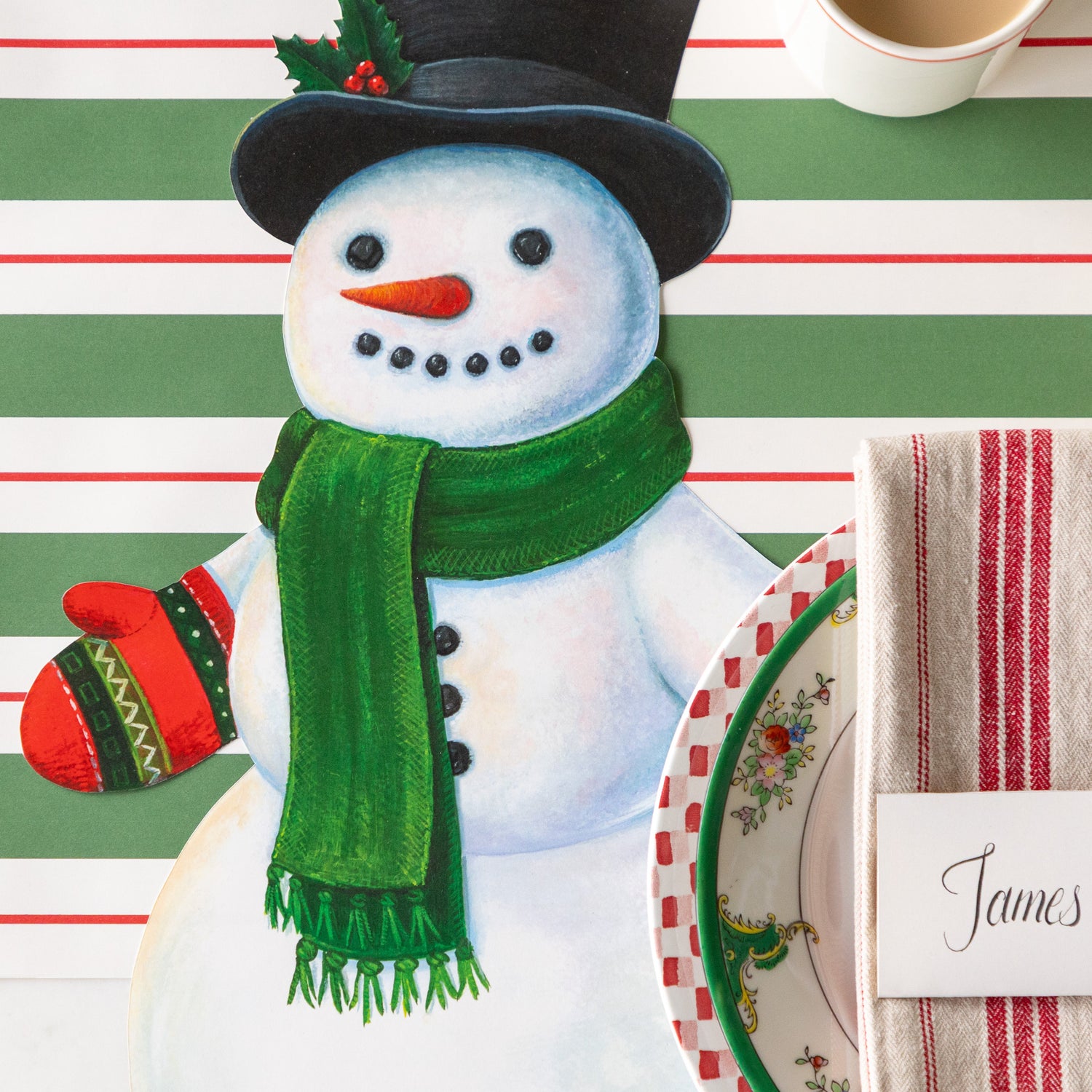 A festive place setting with the Die-cut Jolly Snowman Placemat on the Green &amp; Red Awning Stripe Runner.