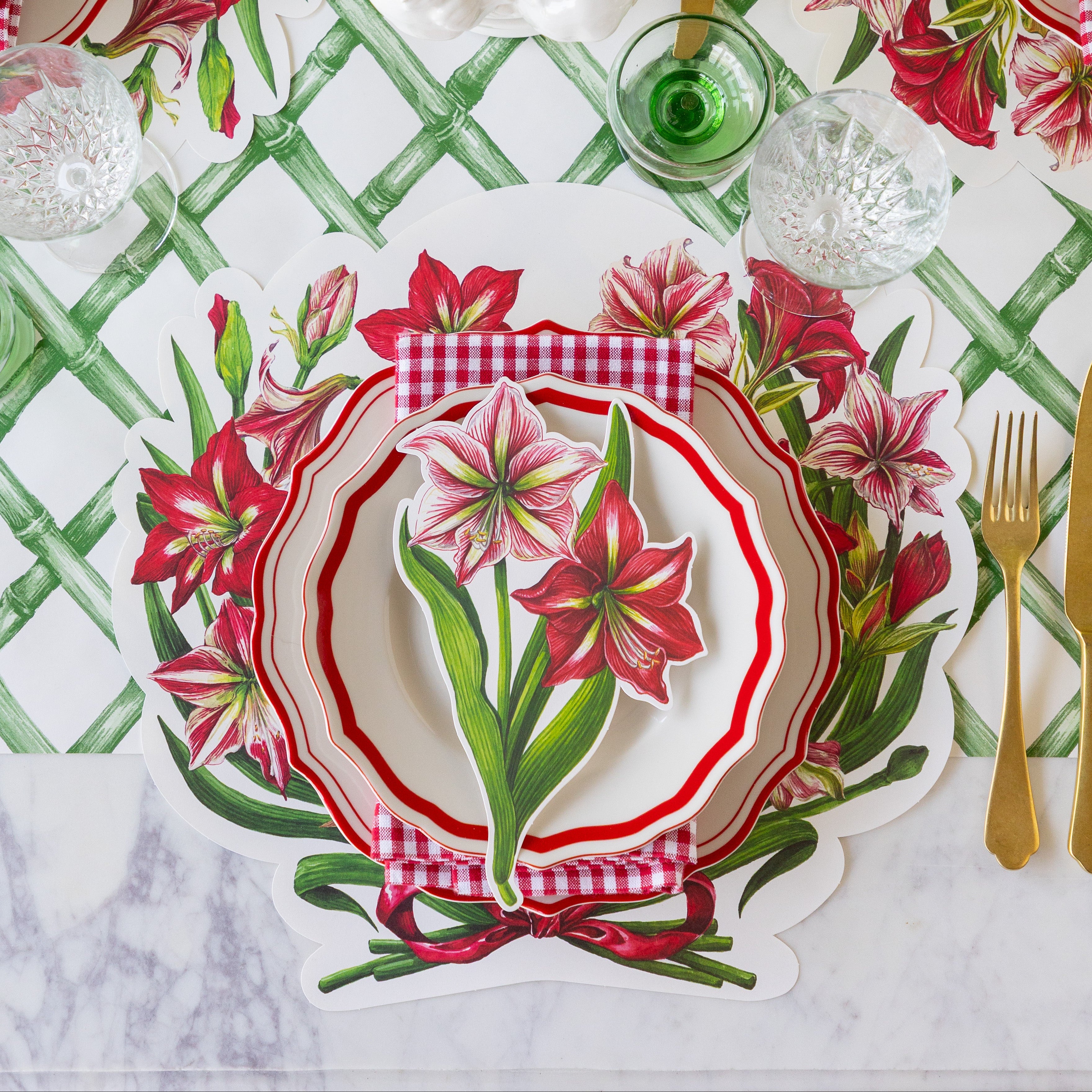 Decorative table setting with the Die-cut Amaryllis Placemat, Red Icing on the Cake plates with the Amaryllis Table Accent atop, and gold flatware on the Green Lattice Runner.