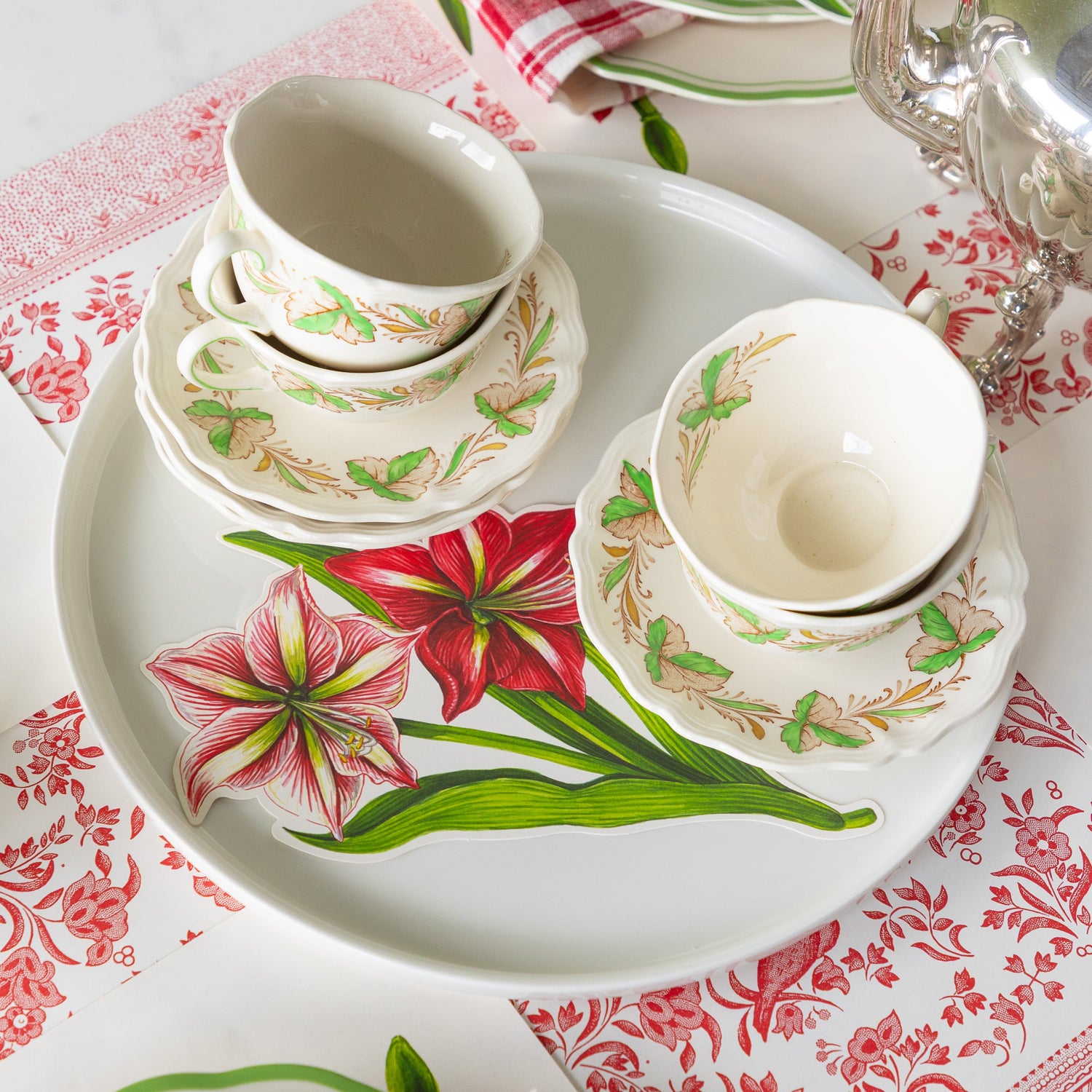 A serving platter with saucers, teacups and Amaryllis Table Accent on top.