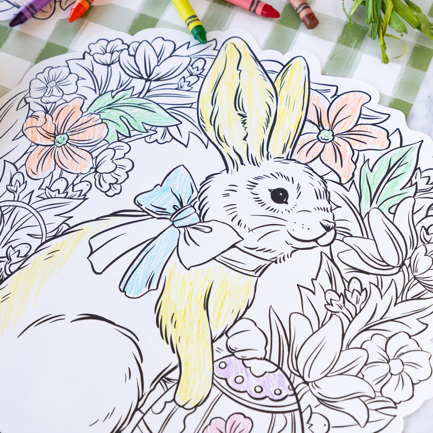 Die-cut Coloring Bunny Wreath Placemat partially colored in on the Moss Painted Check Runner.
