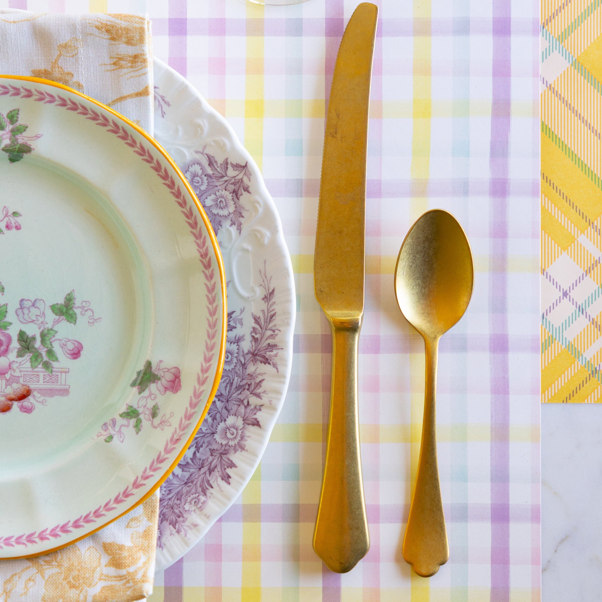 Elegant table setting with floral plates, gold cutlery, and Spring Plaid Placemat.