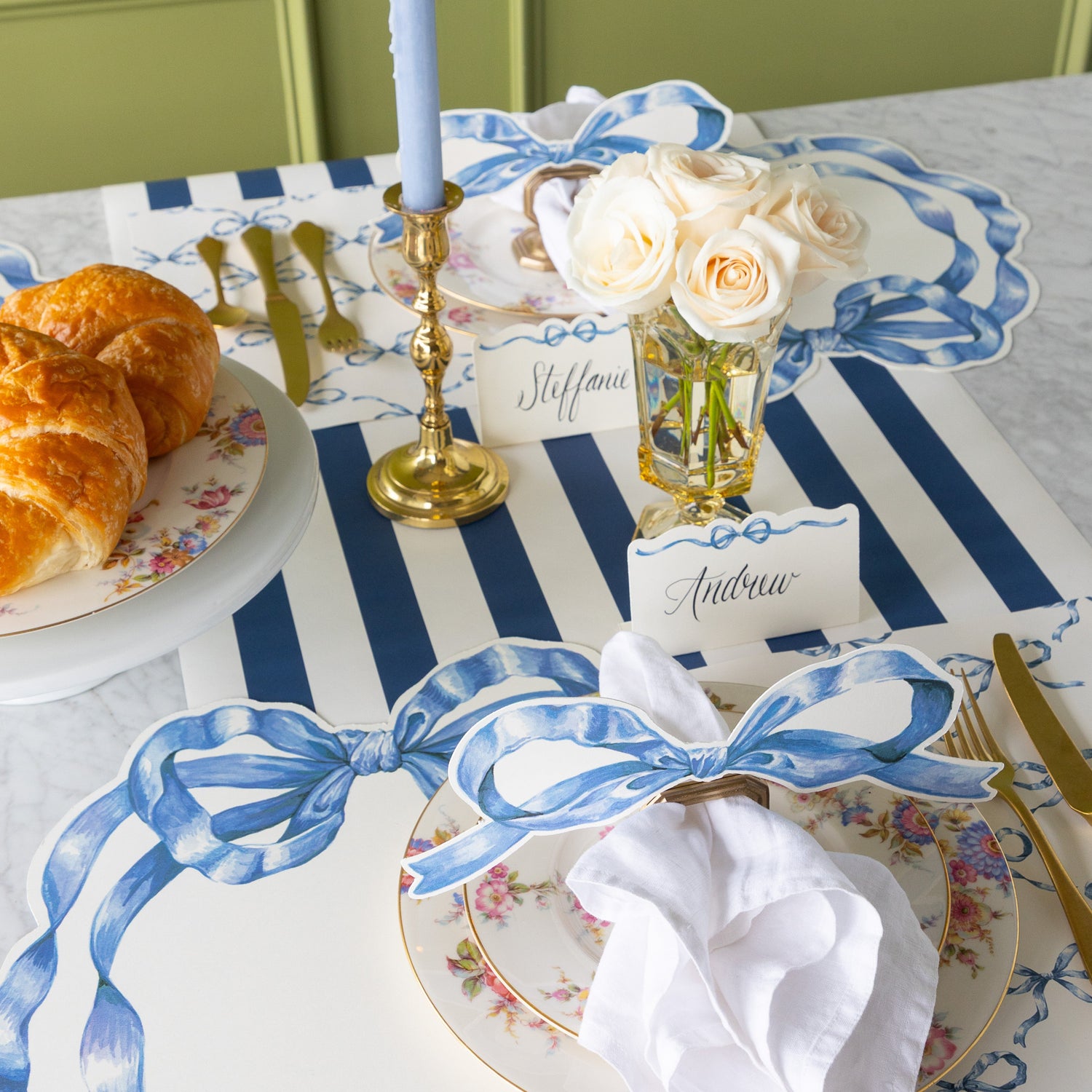 Decorative table setting with flowers and a candle, Heirloom Blue Bow placemats, table accent and place card on the Navy Classic Stripe Runner.