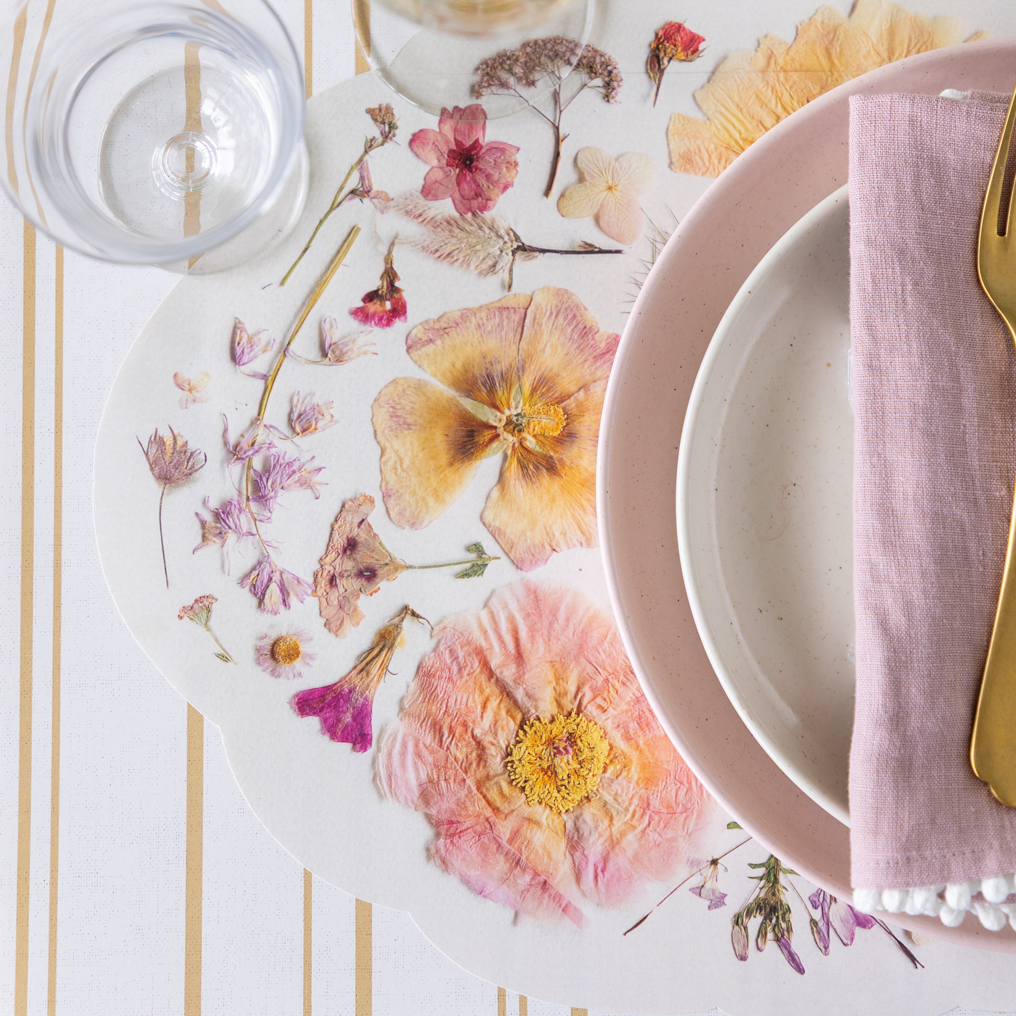 Elegant table setting with Die-cut Blush Petals Placemat, pink napkins, and glasses.