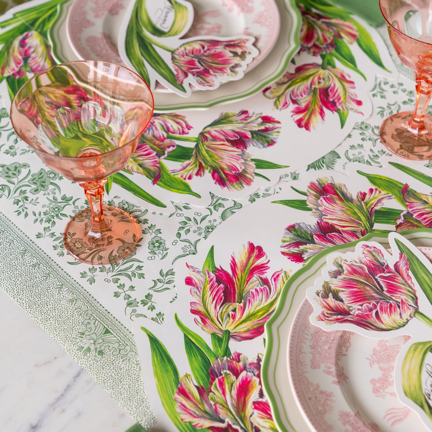 A place setting with the Die-cut Parrot Tulip Placemat on the Green Regal Peacock Runner.