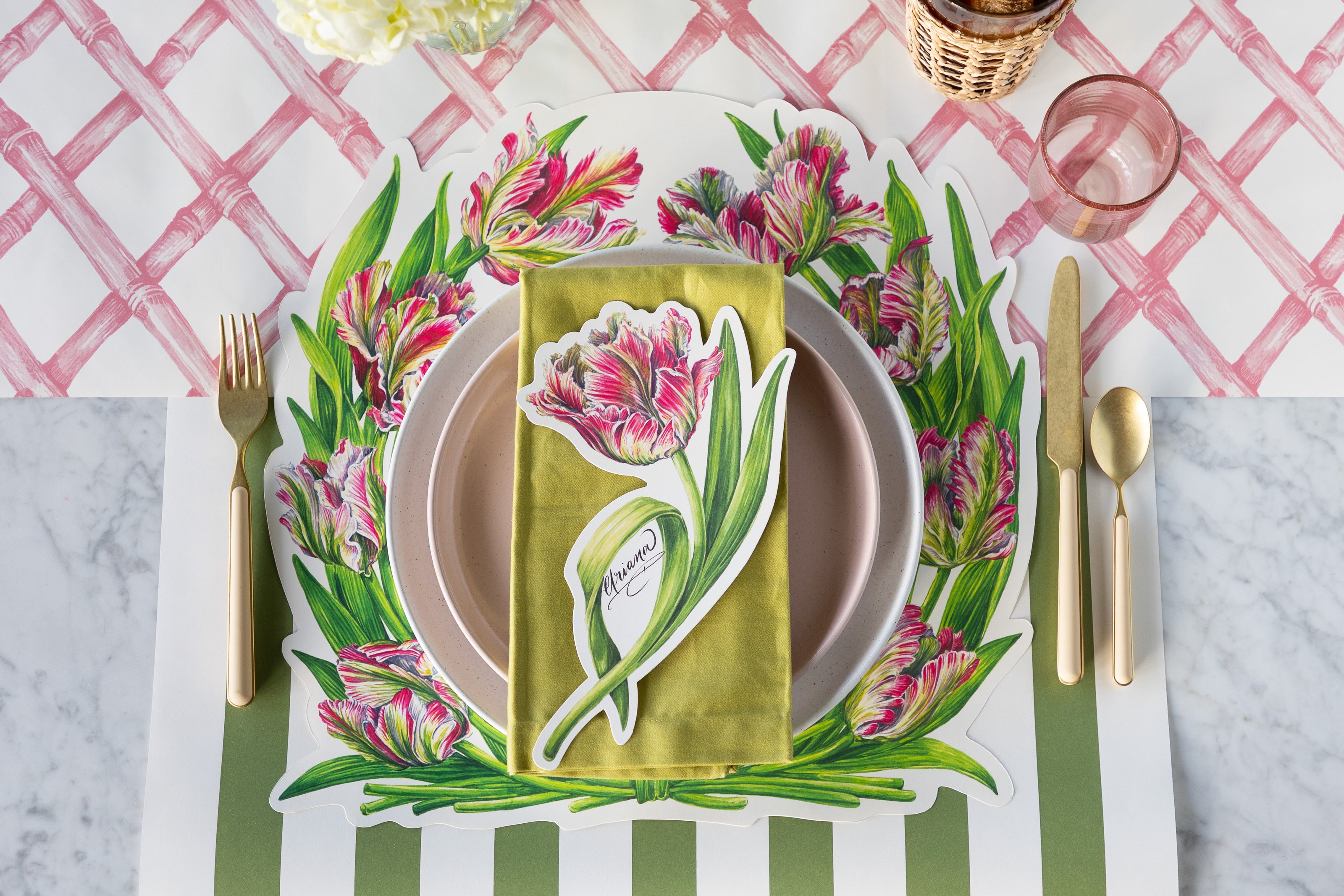 A place setting with the Die-cut Parrot Tulip Placemat on the Pink Lattice and Moss Green Classic Stripe Runners.