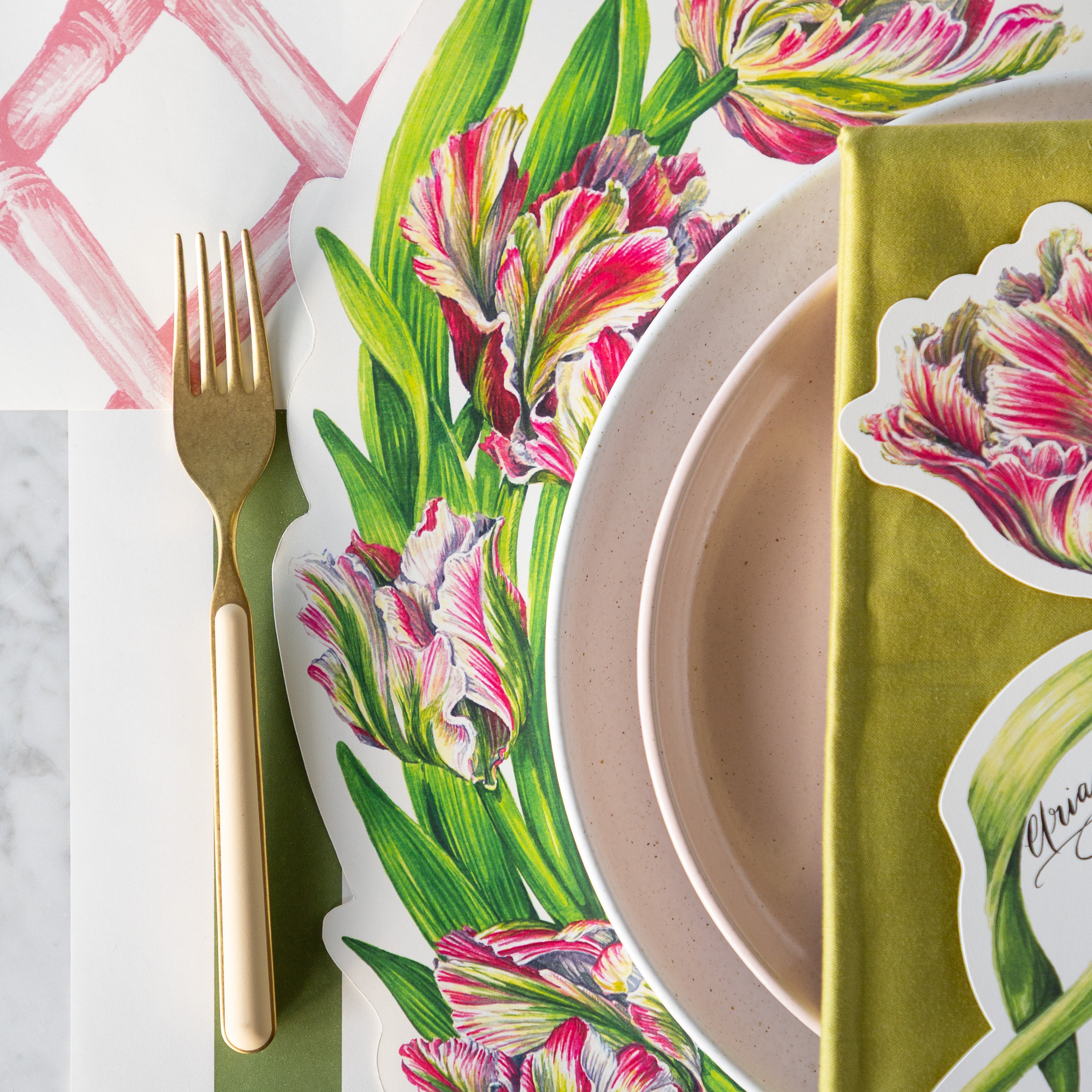 A place setting with the Die-cut Parrot Tulip Placemat on the Pink Lattice and Moss Green Classic Stripe Runners.