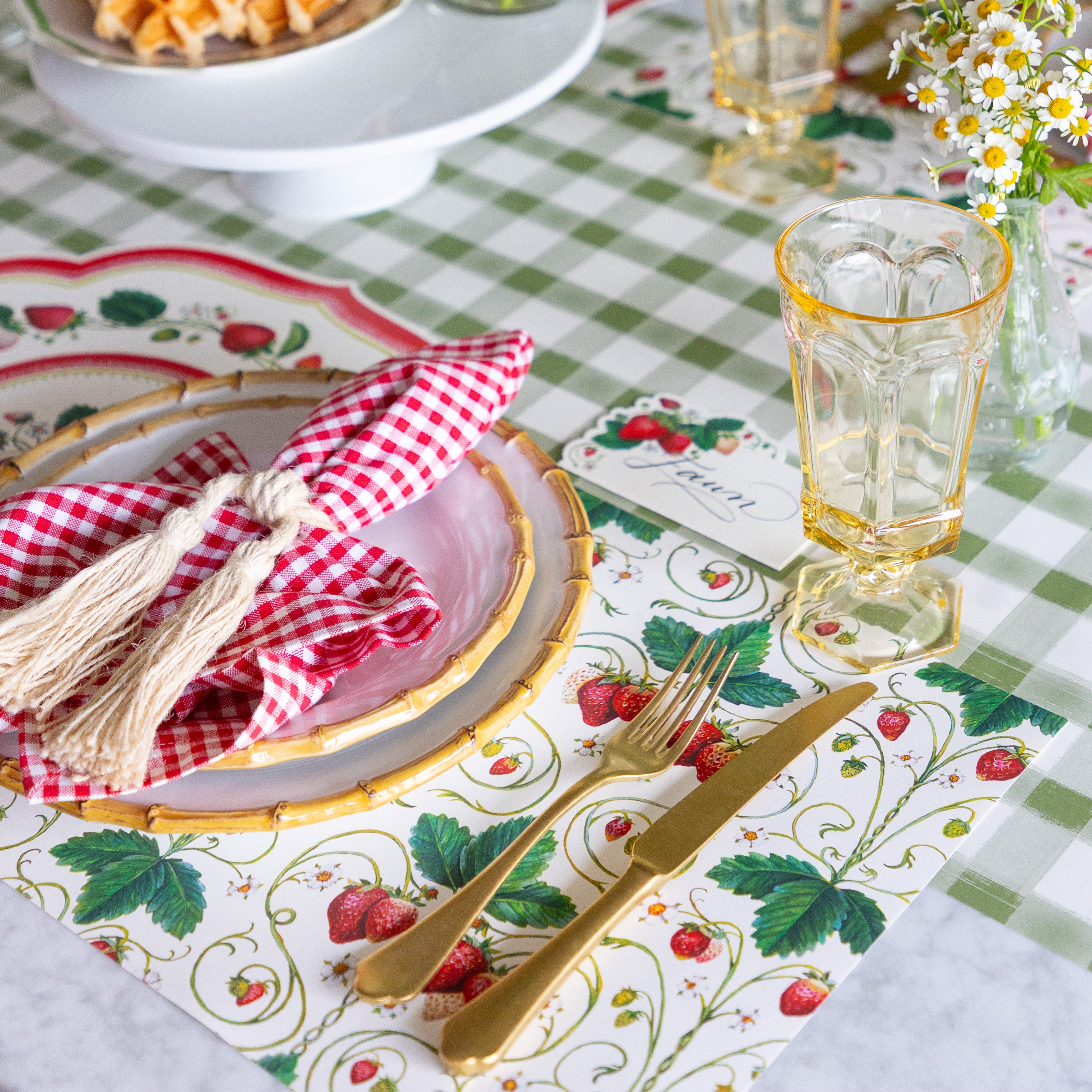 A place setting with the Strawberry Fields Placemat and Strawberries Place Card on the Moss Painted Check Runner.
