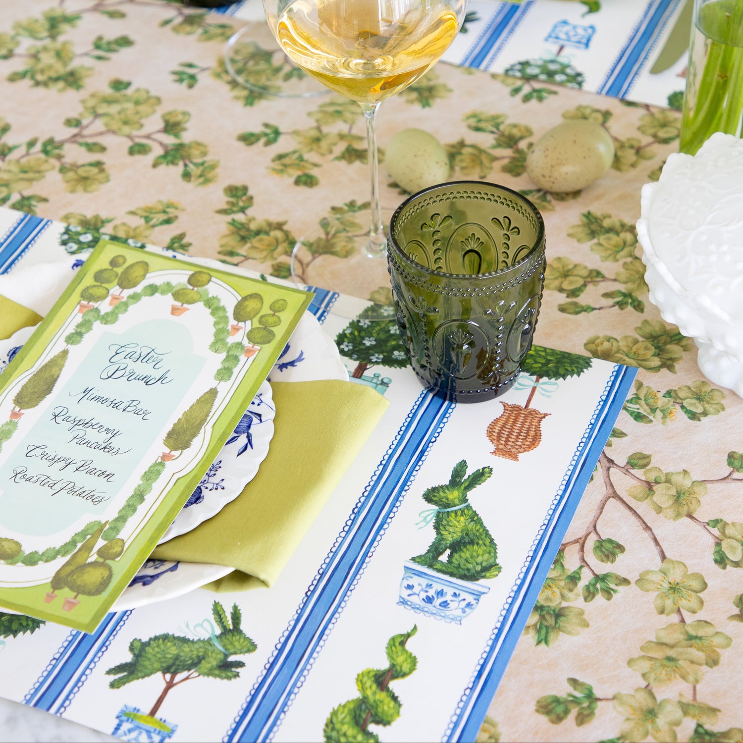 Easter-themed table setting with Spring Topiary Placemat on the Green Cherry Blossom Runner.