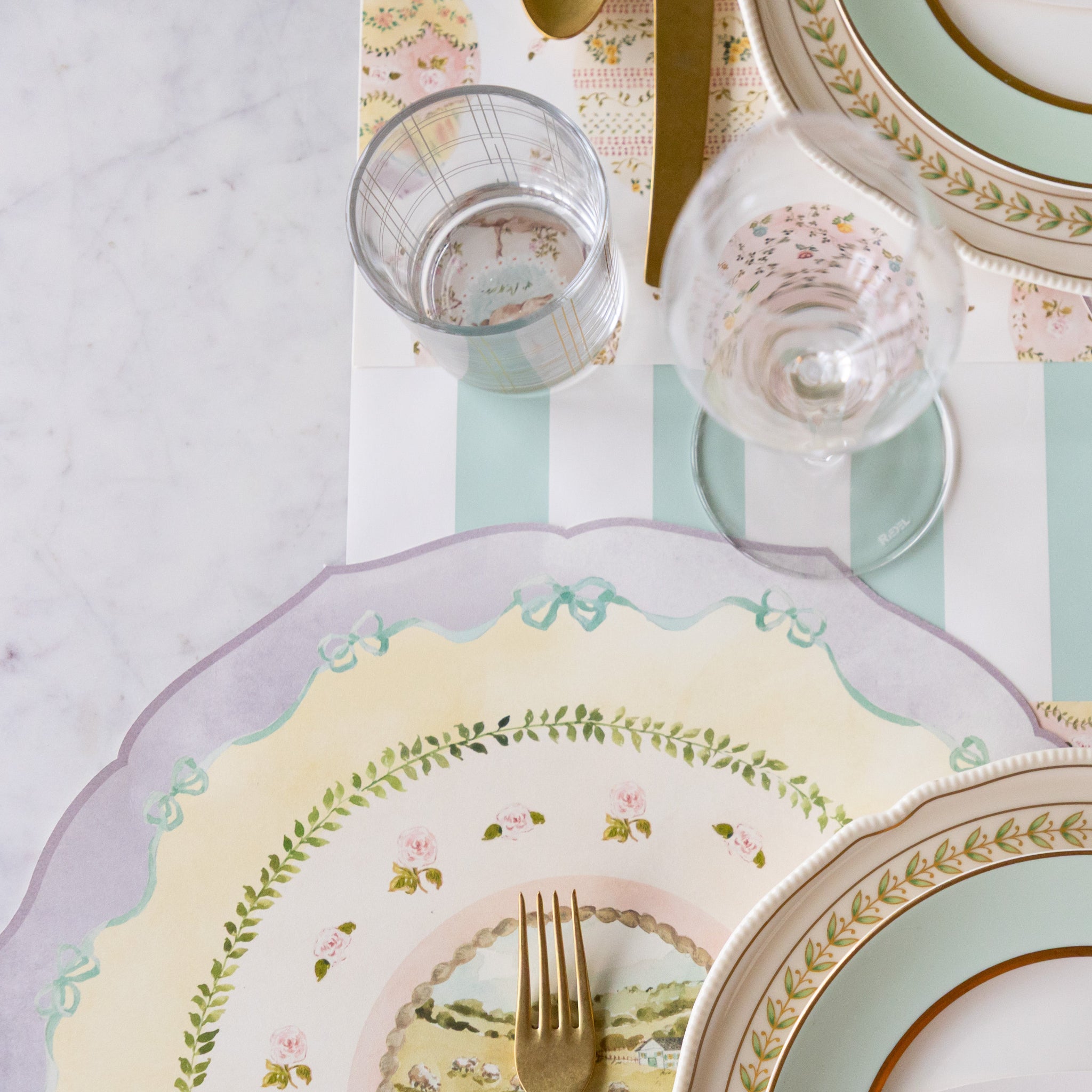 Elegant table setting with decorative plates, glasses, cutlery and Die-cut Spring Meadow Placemat on the Seafoam Classic Stripe Runner.
