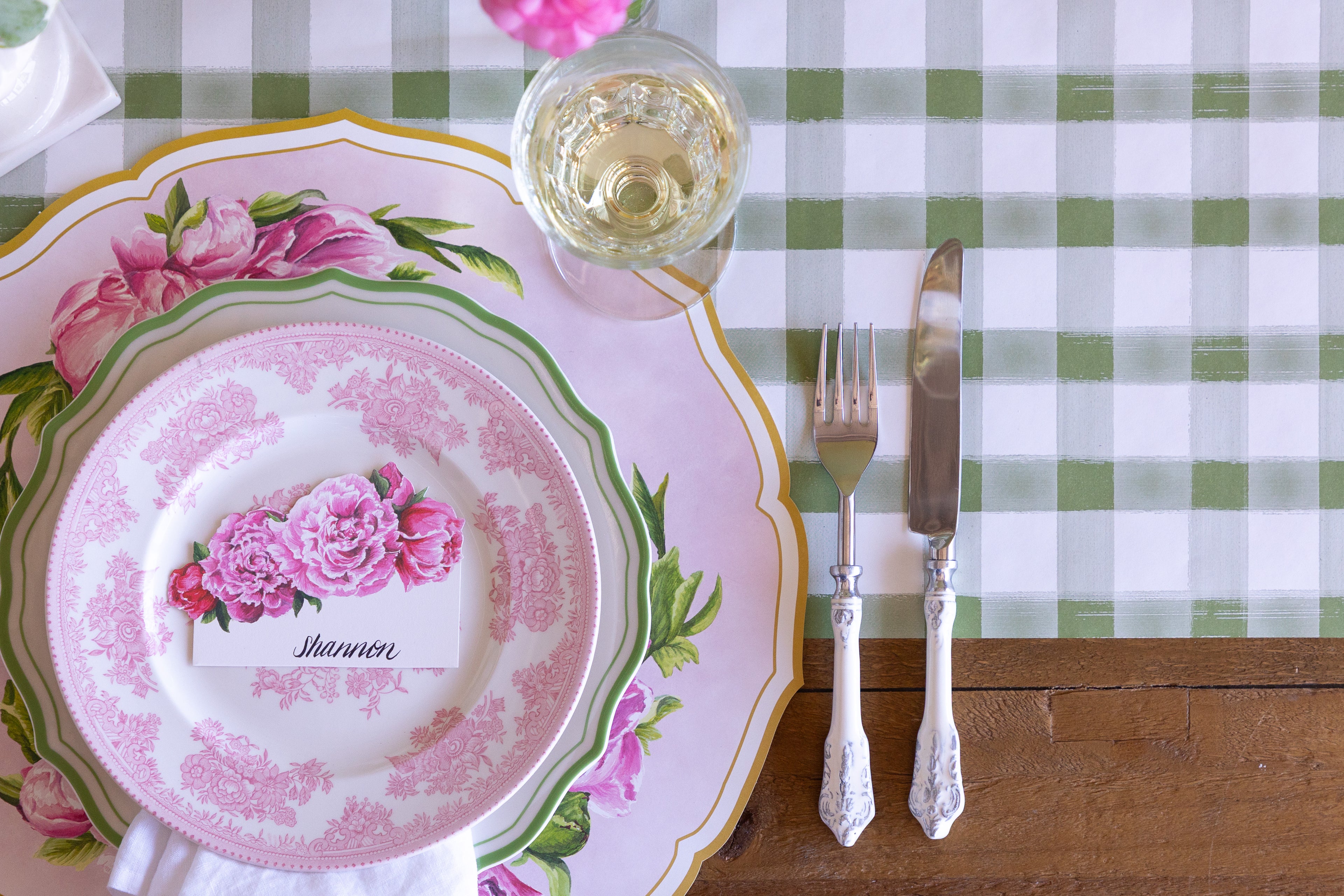 Decorative place setting with Die-cut Peony China Placemats, green rimmed and pink floral plates, vintage cutlery and flowers on the Moss Painted Check Runner.