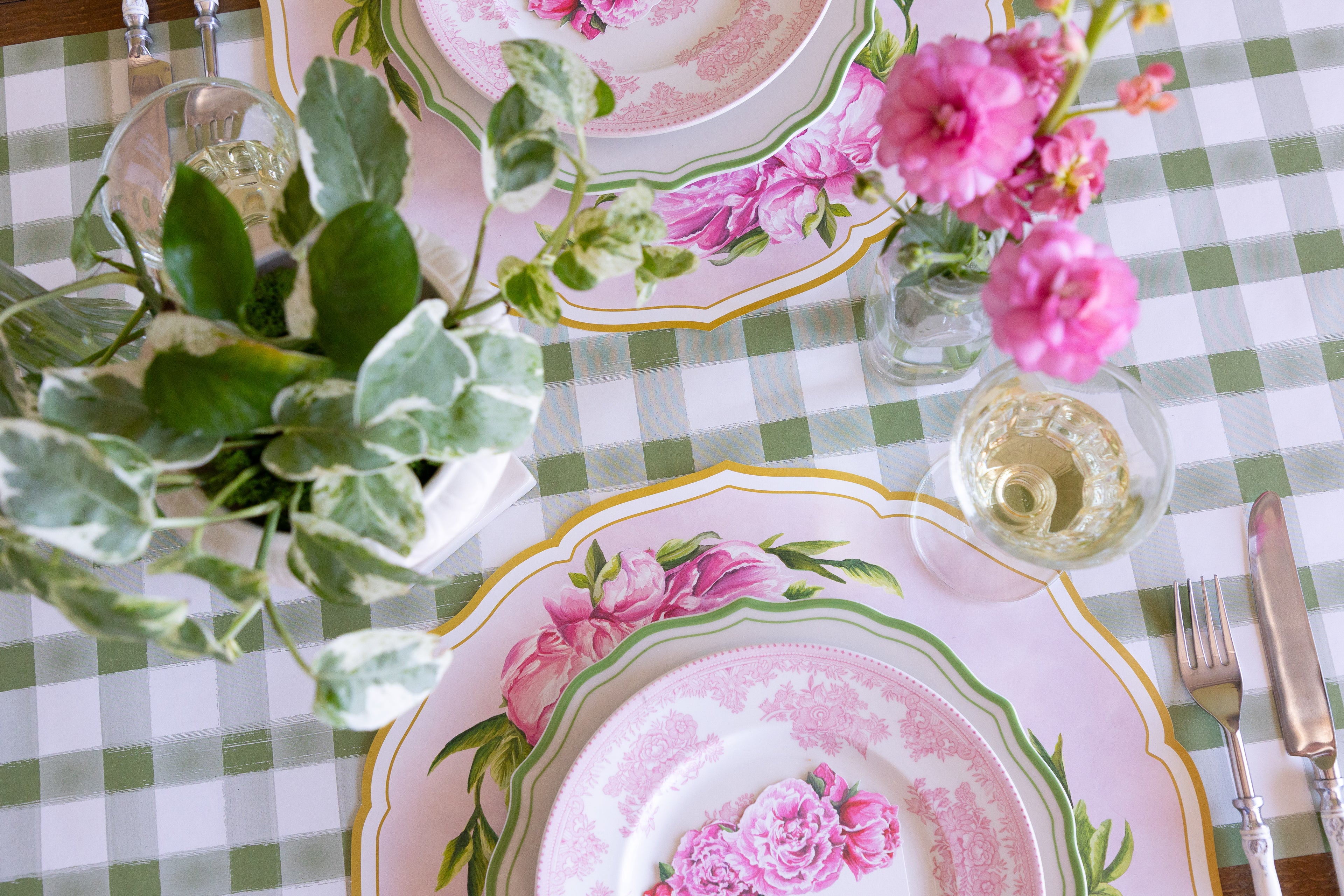 Decorative place setting with Die-cut Peony China Placemats, green rimmed and pink floral plates, vintage cutlery and flowers on the Moss Painted Check Runner.