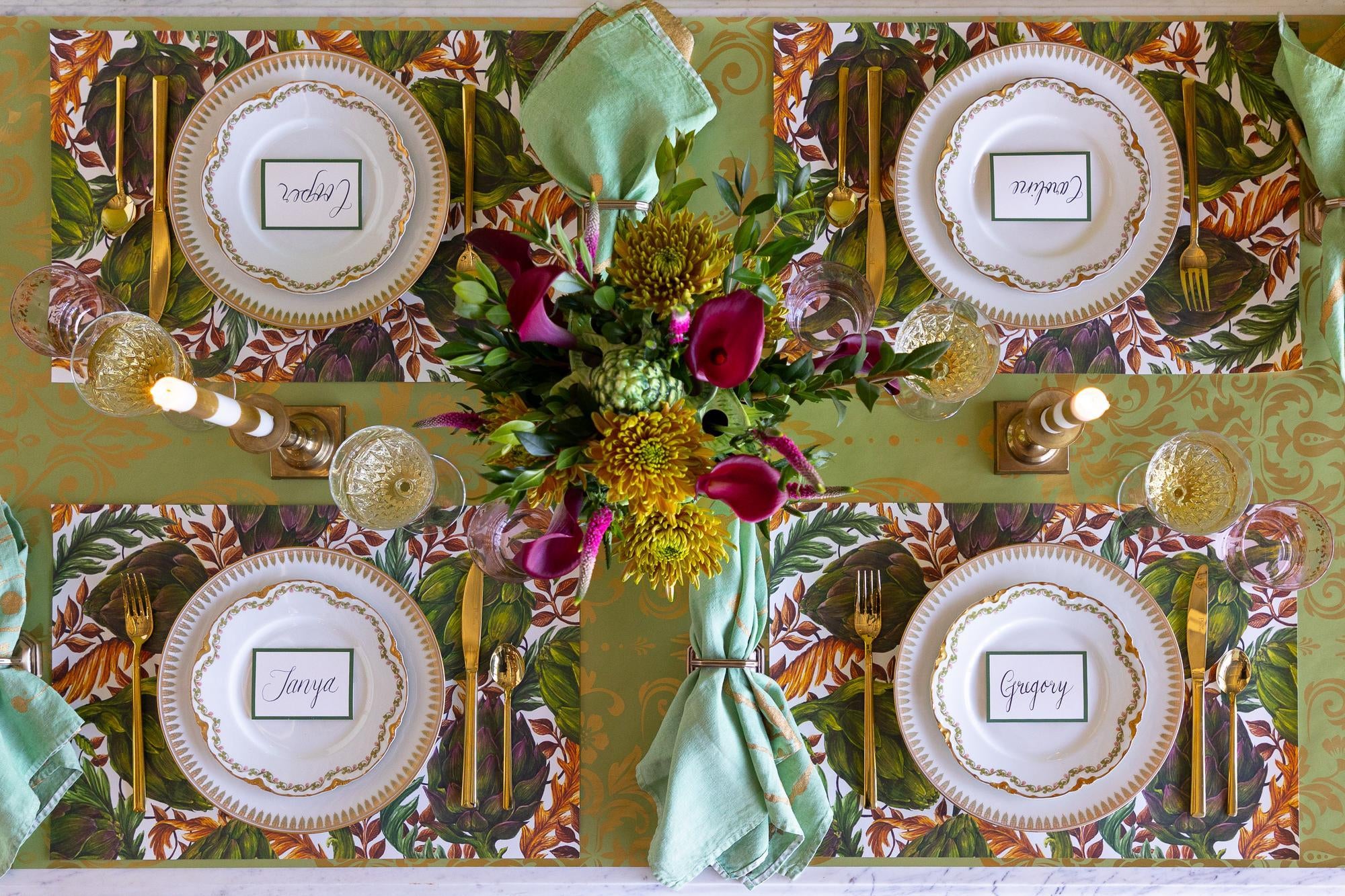 Decorative table setting with floral centerpiece, plates, and place cards.