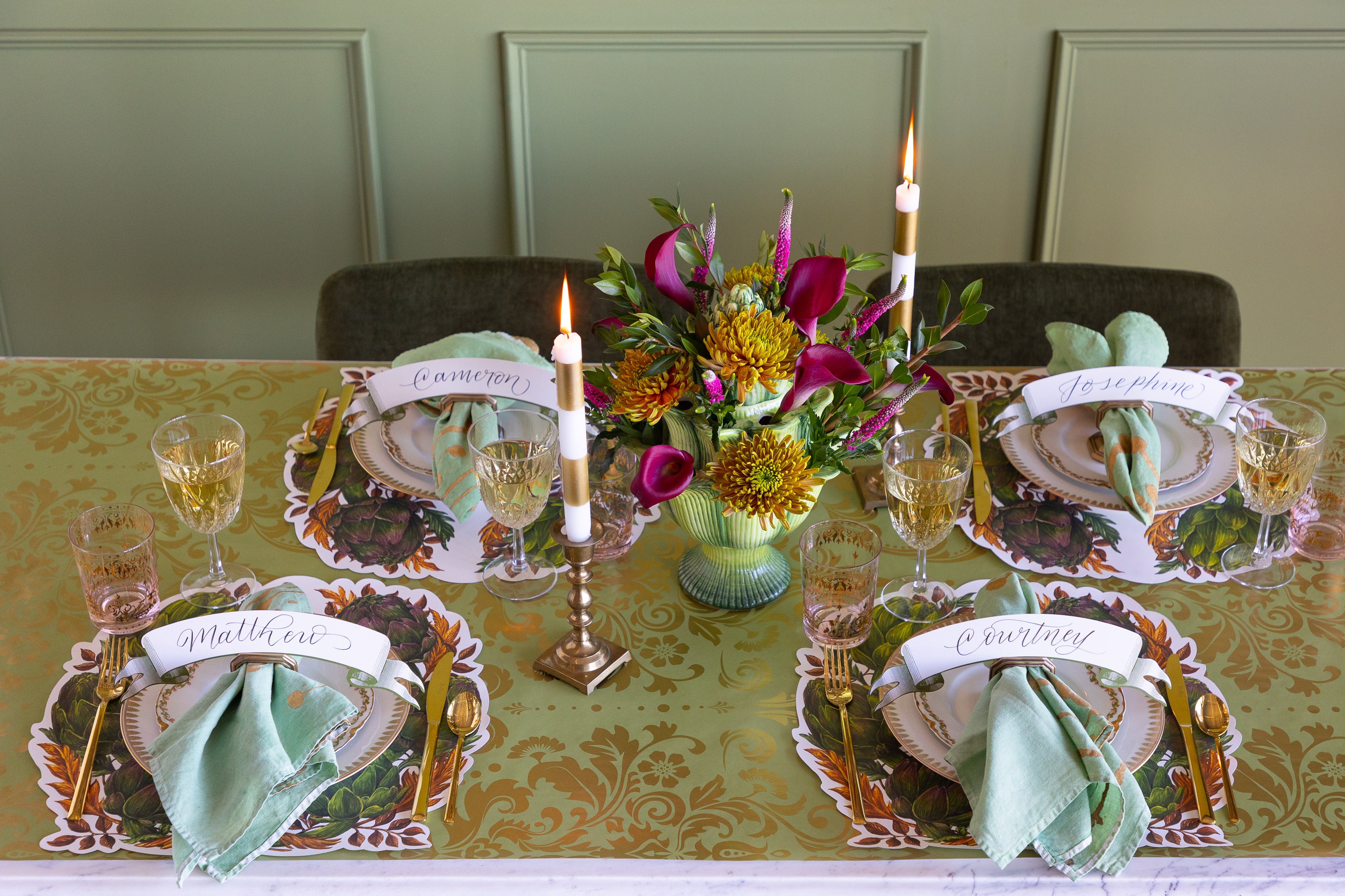 Elegant table setting with Die-cut Artichoke Wreath Placemats and a flower arrangement and candles lit. 