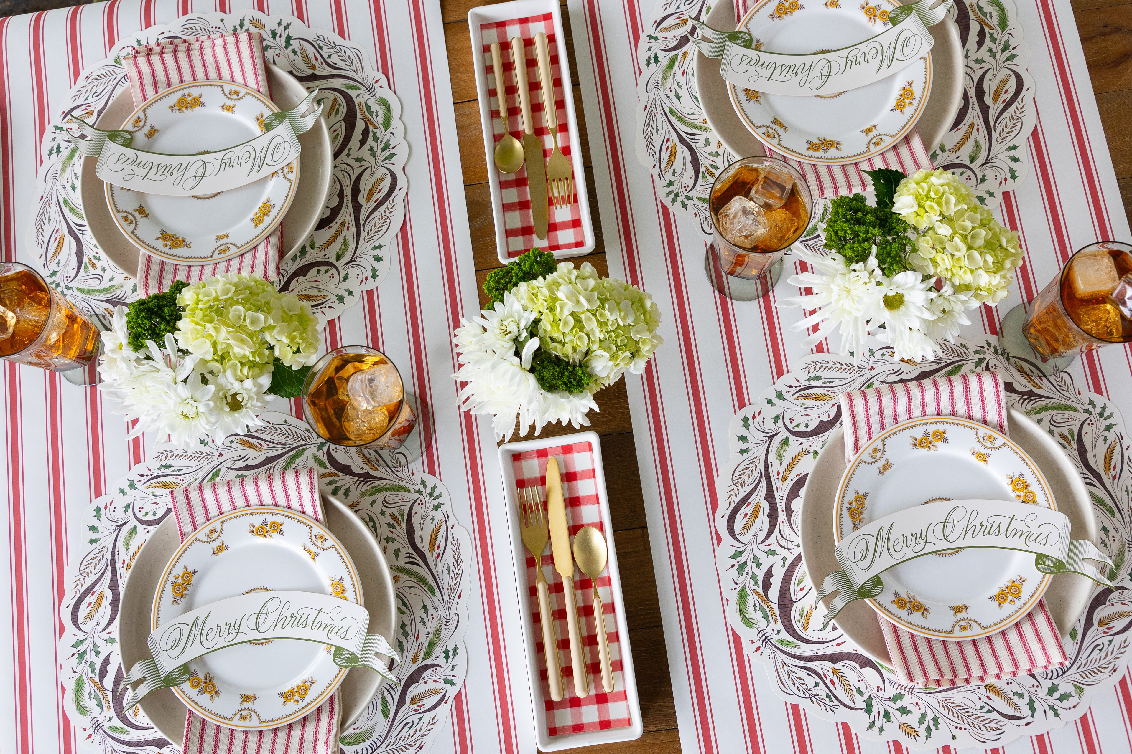Festive table setting for four featuring the Die-cut Merry Christmas Placemat, vintage dinnerware, glasses and flowers on the table. 
