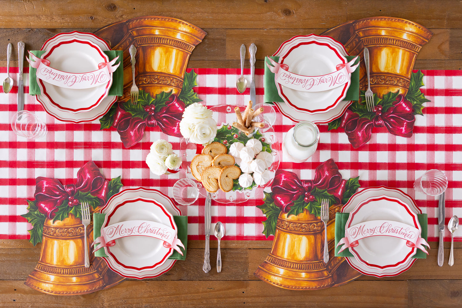 Christmas-themed place settings with Die-cut Christmas Bells Placemats, red bow, and &