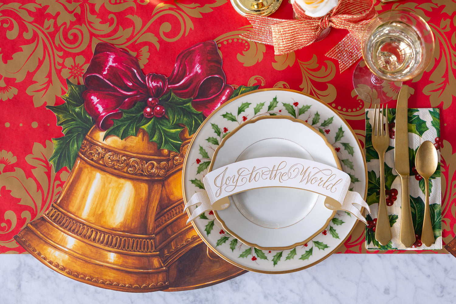 Christmas-themed place setting with Die-cut Christmas Bells Placemat, red bow, and &