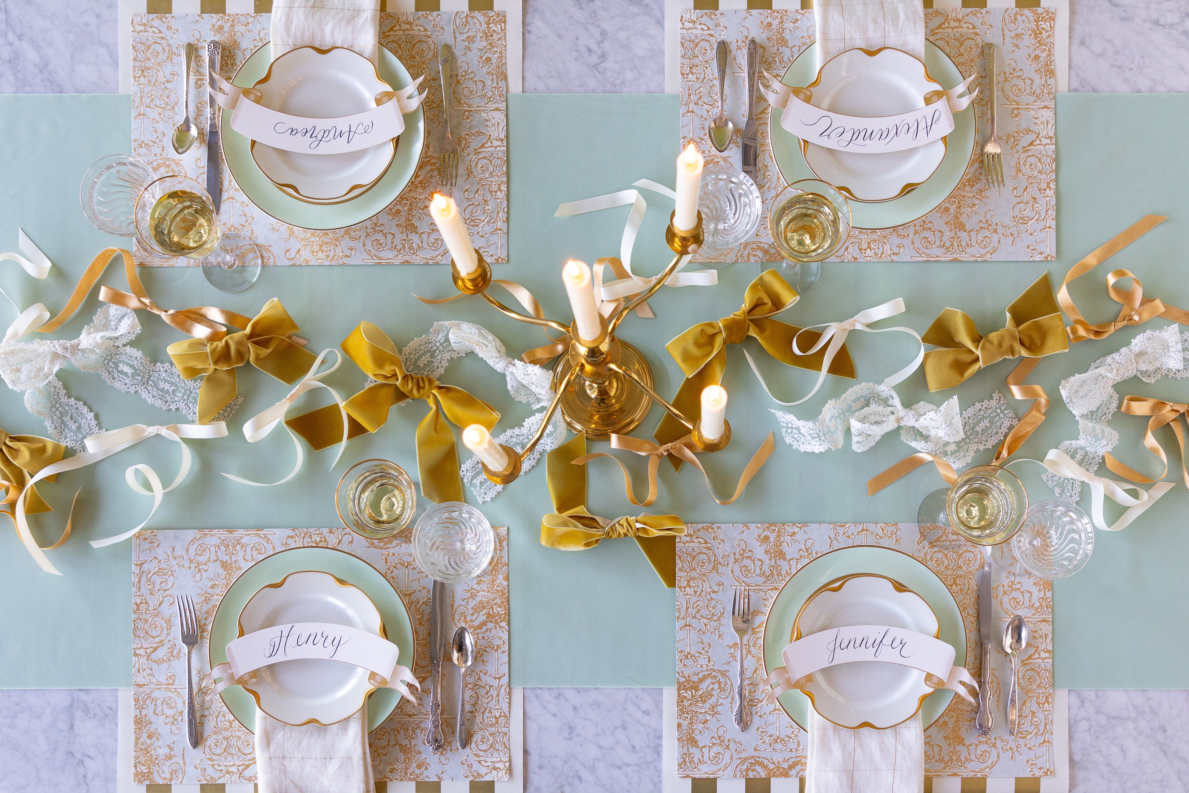 Elegant table setting with bows made of different fabrics strewn down the center of a table on a Seafoam Seafoam Flocked Runner. 